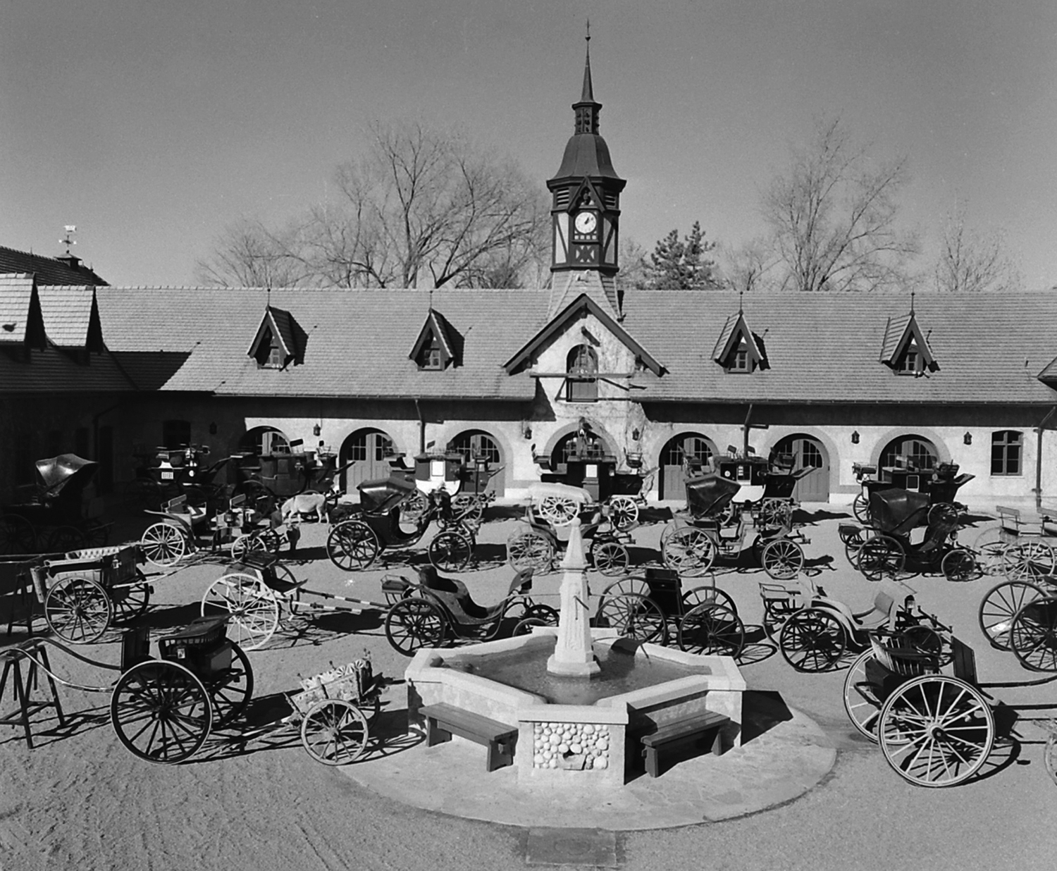 Carriage collection at the Bauernhof ranges from six three-ton coaches aligned at the rear to gigs and donkey cart in front and a ladies' phaeton and French sailor wagon right behind fountain.