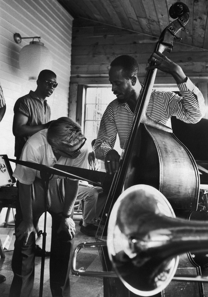 Jazz hopeful Walter Bernard bends low to peer at the fast fingers of bass fiddle instructor Percy Heath at a summer workshop for jazz at Lenox, Mass. The school started up three years ago and has The Modern Jazz Quartet in residence.