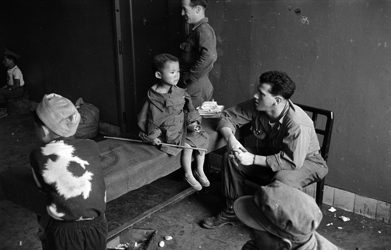 Korean War orphan Kang Koo Ri with American troops, 1951.