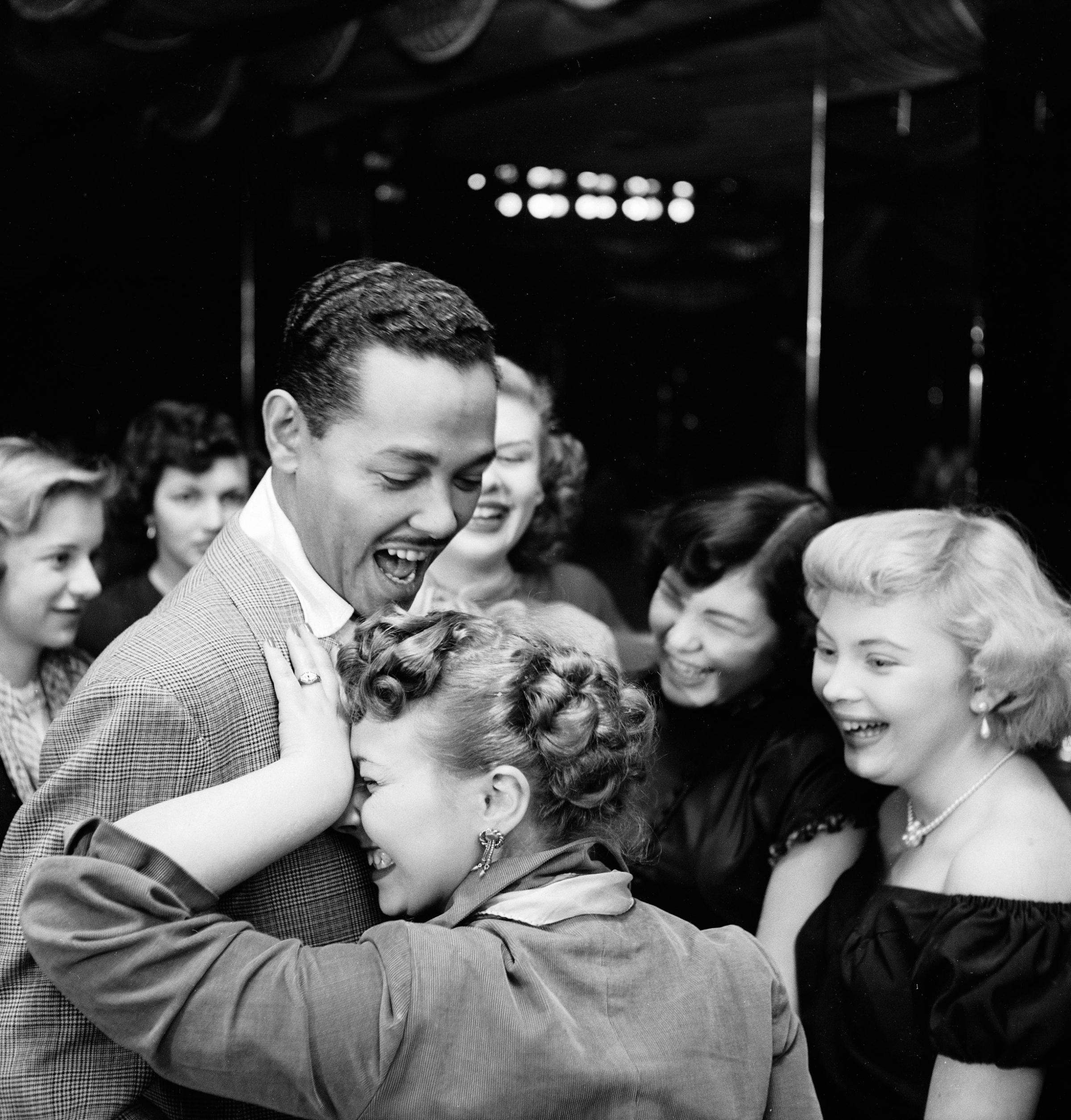 Singer and bandleader Billy Eckstine gets a hug from an adoring fan after a show at the late, great New York City jazz club, Bop City, 1949.
