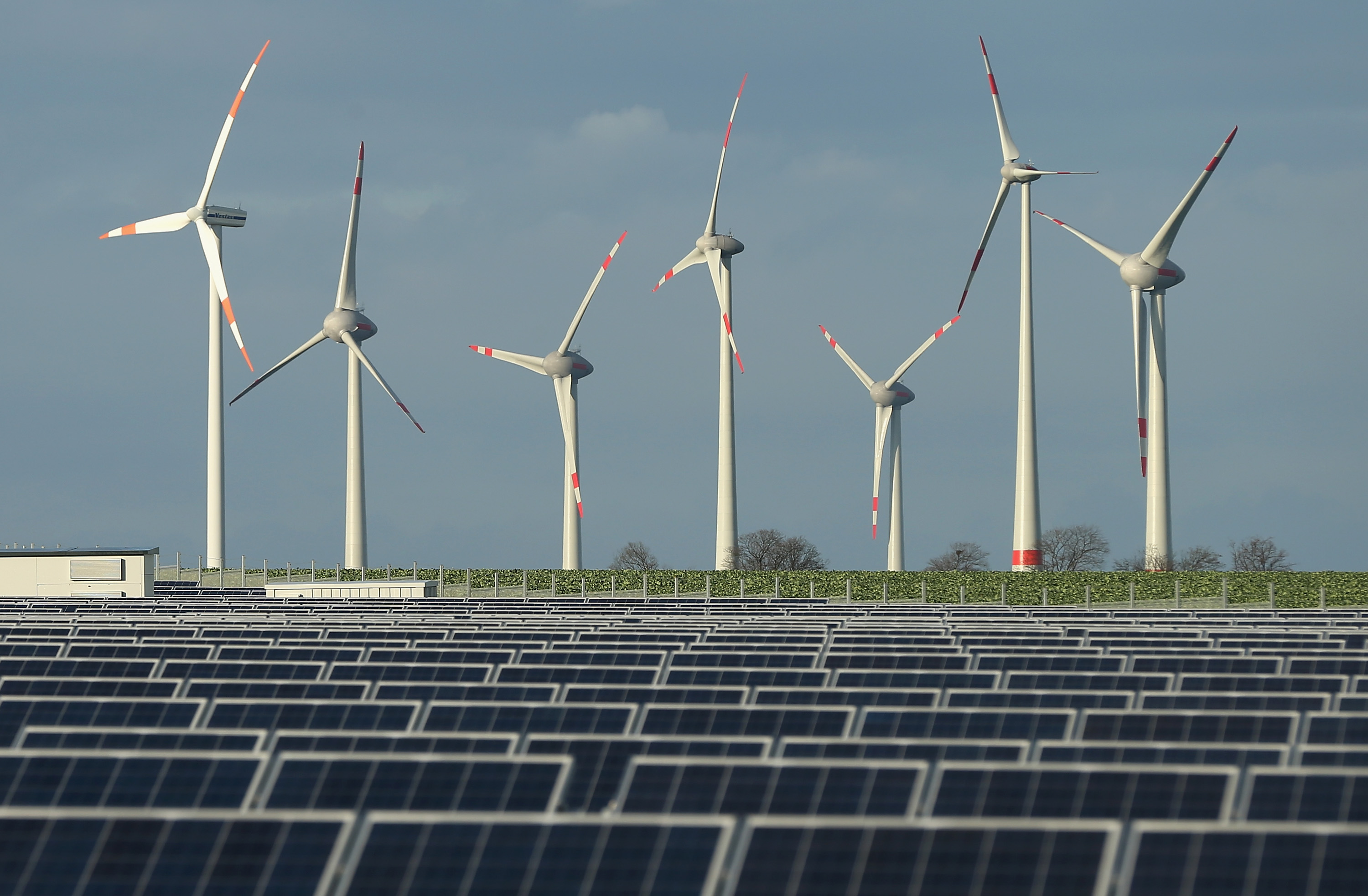 Wind turbines stand behind a solar power park on October 30, 2013 near Werder, Germany. (Sean Gallup—Getty Images)