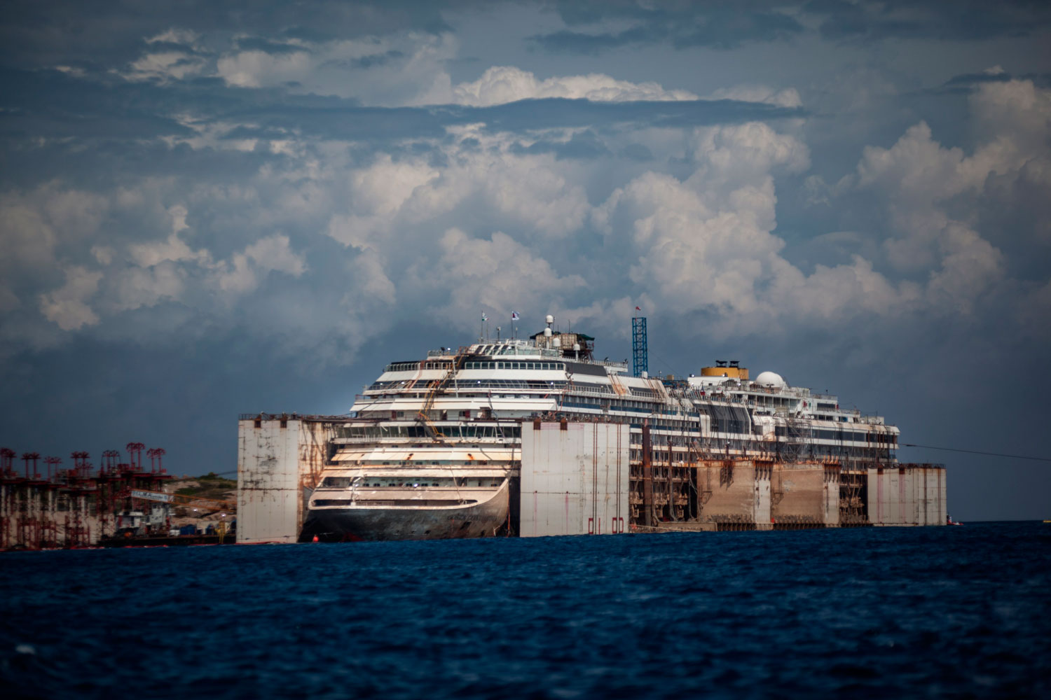 Costa Concordia re-float operation close to the end on July 21, 2014 in Giglio Porto, Italy. Air-filled steel boxes acted as pontoons, forcing the ship into an upright position.