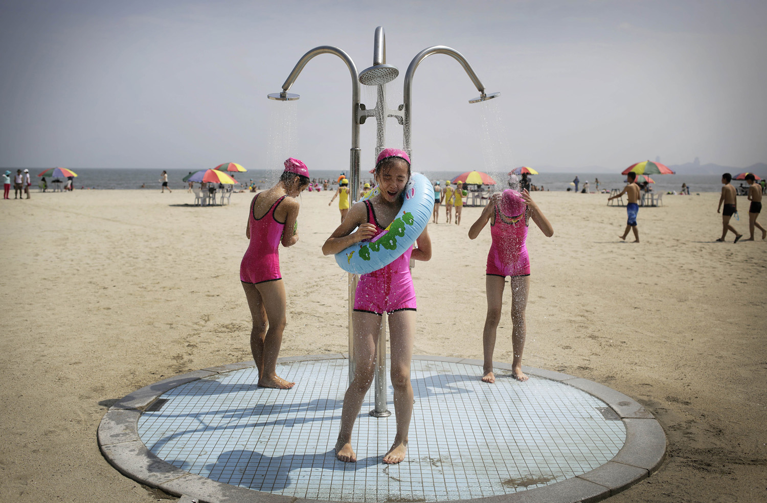 North Korean girls in similar bathing suits stand under a shower at the Songdowon International Children's Camp, Tuesday, July 29, 2014, in Wonsan, North Korea.