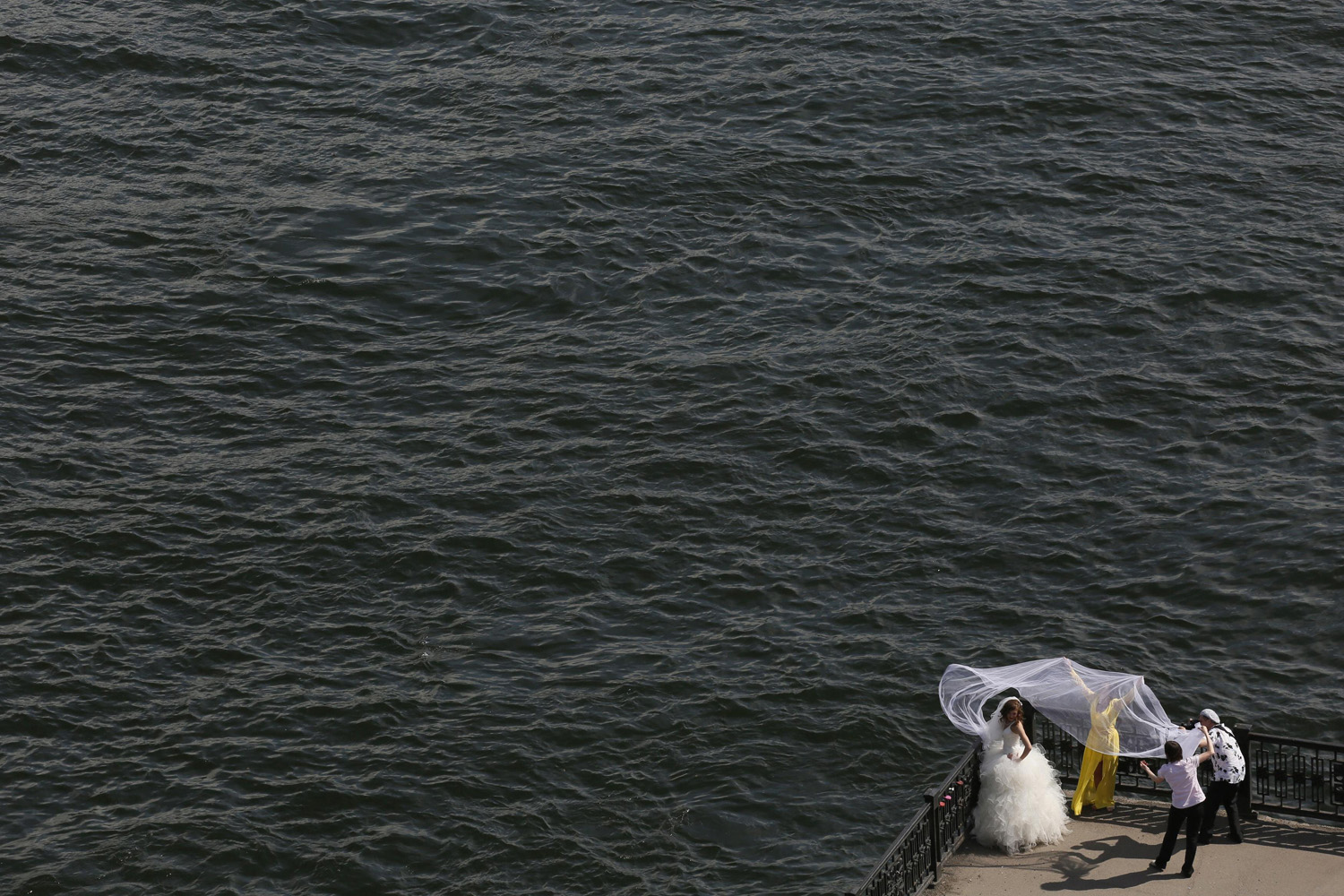 Bride poses for a photographer on an embankment at the Yenisei River in Russia's Siberian city of Krasnoyarsk