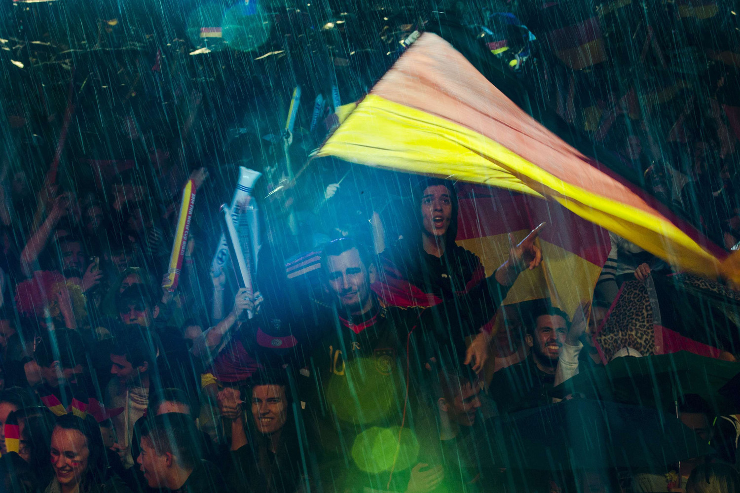 People watch Germany play against Algeria during their 2014 World Cup round of 16 game, during heavy rain at public viewing arena in Berlin