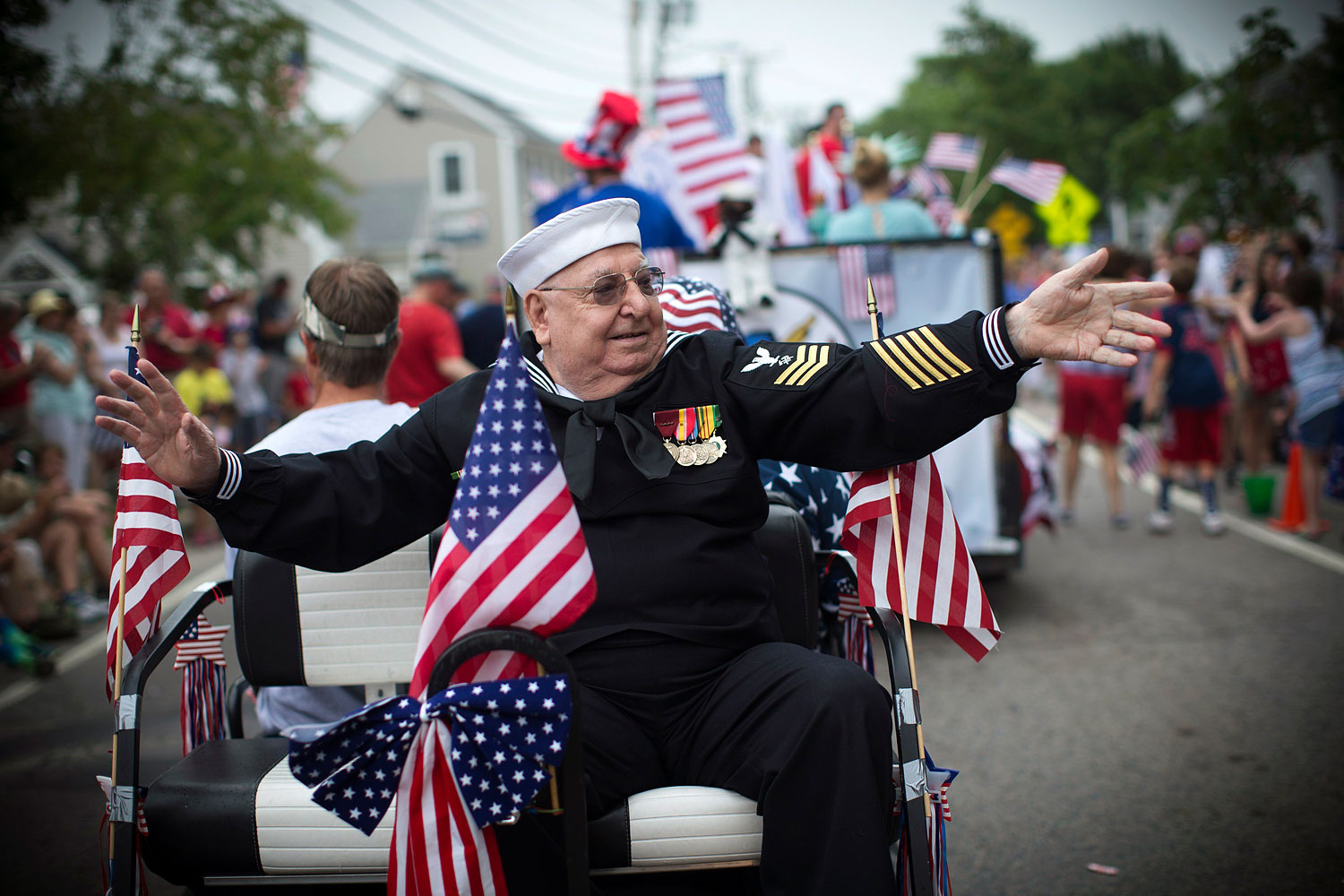 Petrus Kerras, a decorated U.S. Navy veteran of both the Korean and Vietnam wars, rides on a float in a July Fourth parade in the village of Barnstable, Mass. July 4, 2014.