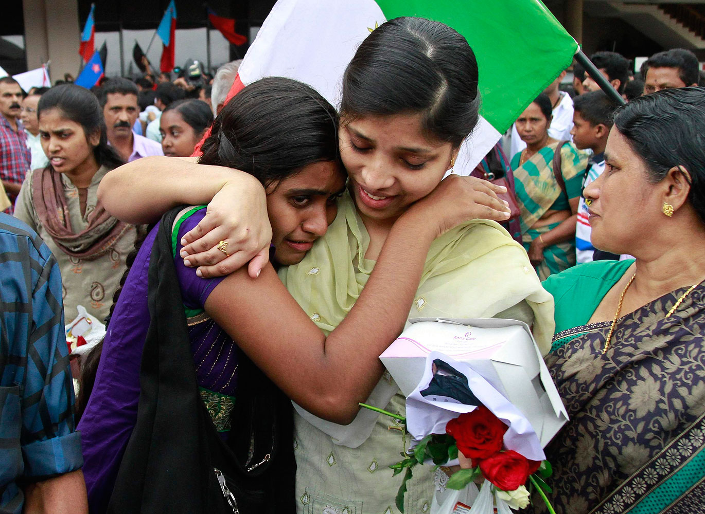 Sherin, center, an Indian nurse caught up in fighting in Iraq, hugs her sister after arriving at the airport in the southern Indian city of Kochi, July 5, 2014. (Sivaram V—Reuters)