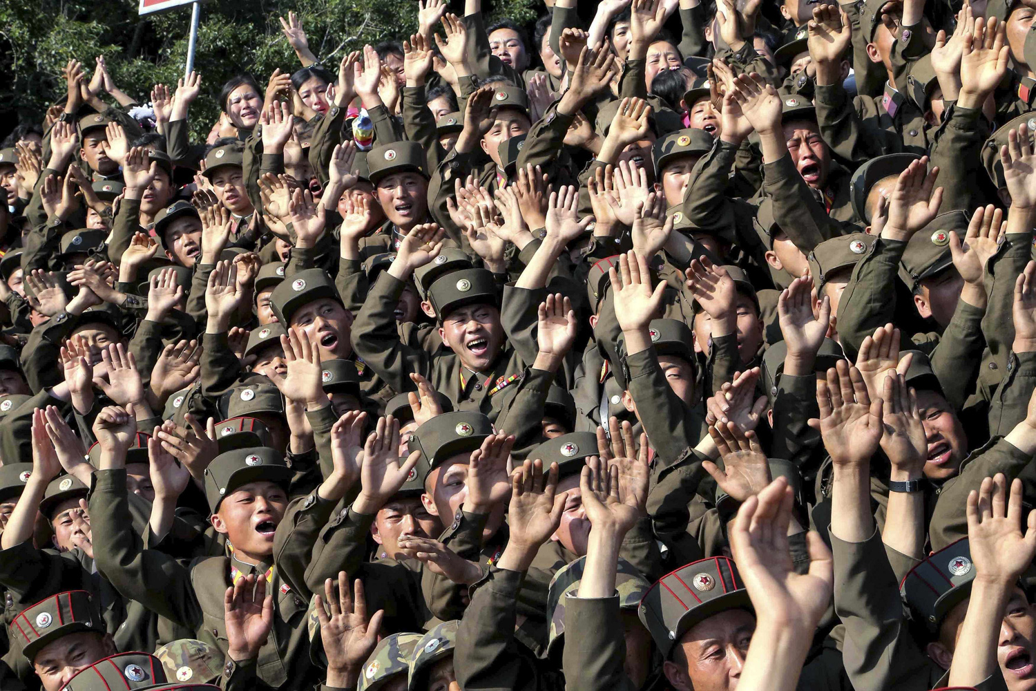 Soldiers wave during a visit by North Korean leader Kim to inspect the defence detachment on Ung Islet