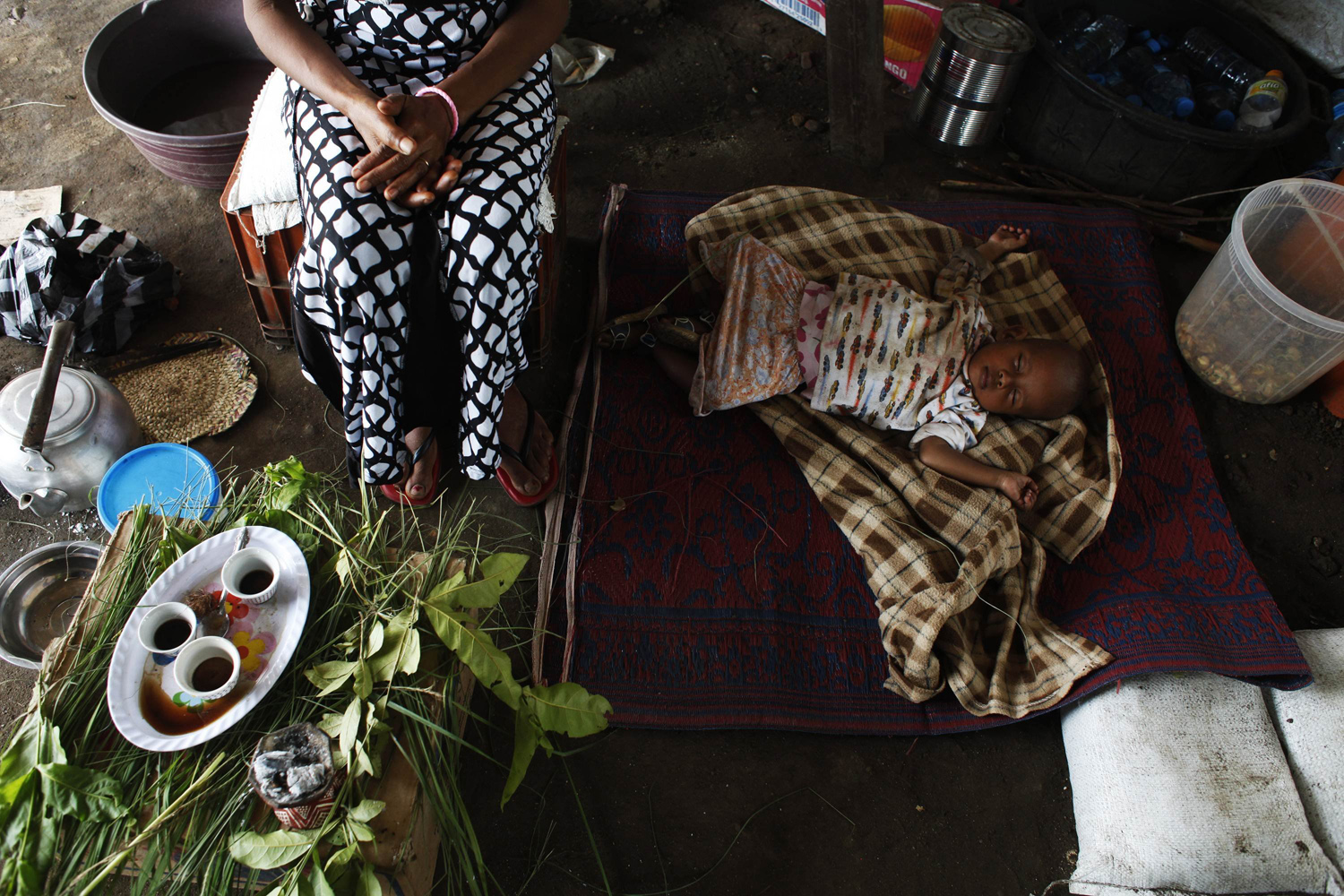 Jul. 8, 2014. An Eritrean baby refugee sleeps on the floor by his mother in a tent inside the UN House IDP camp in Juba.