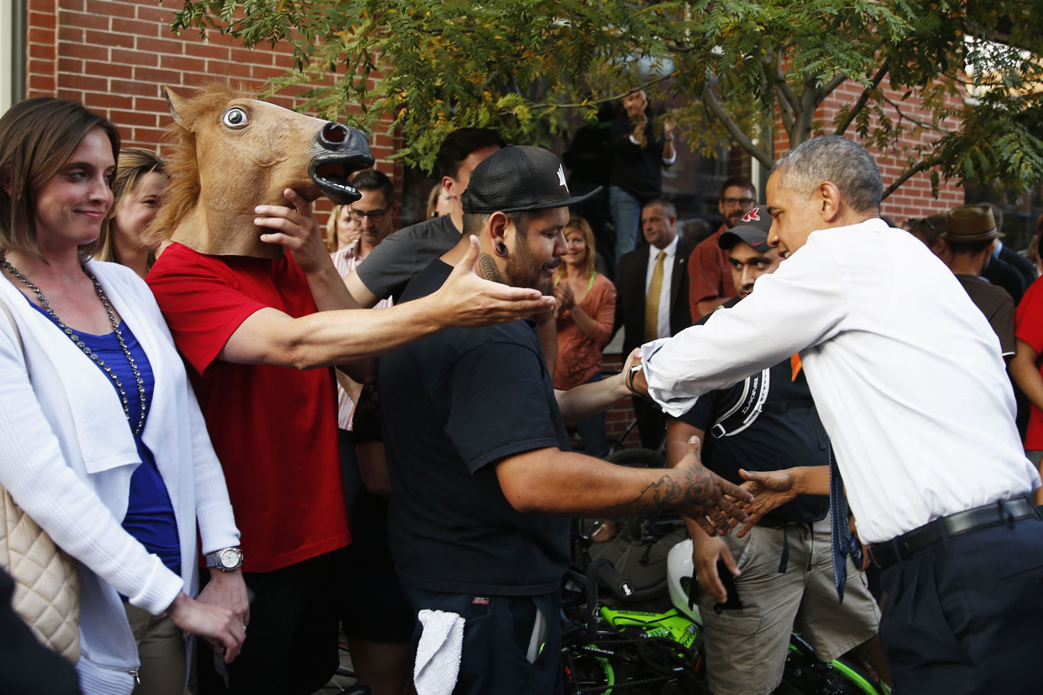 A man wearing a horse mask reaches out to shake hands with President Barack Obama during a walkabout in Denver on July 8, 2014.