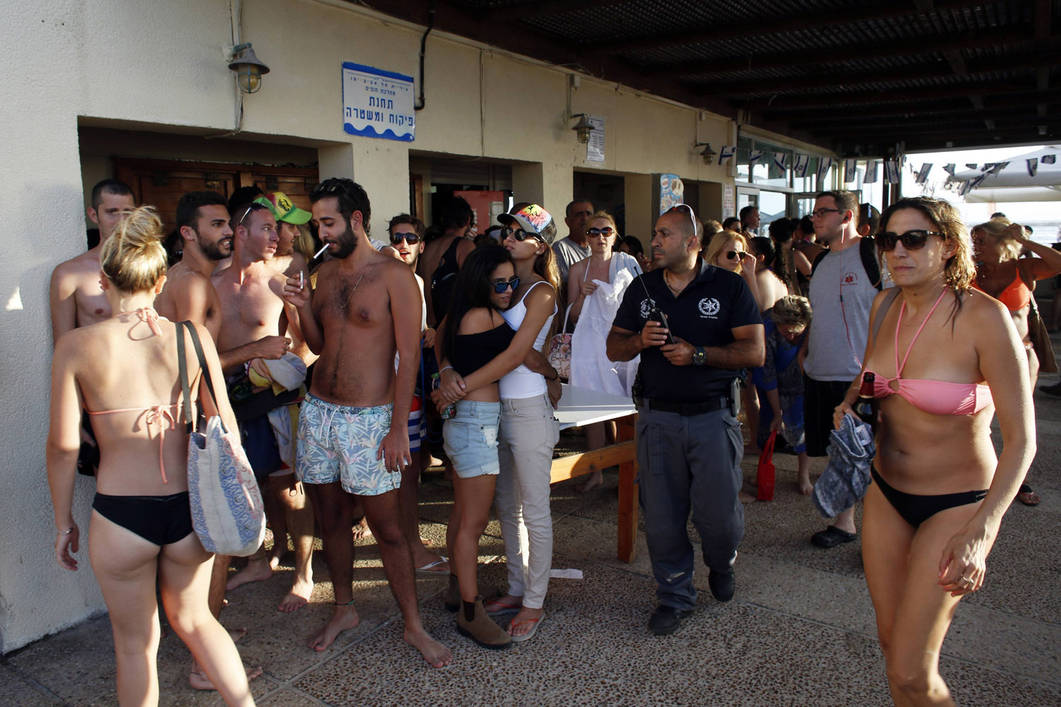 Beach-goers take shelter as a siren sounds warning of incoming rockets in Tel Aviv