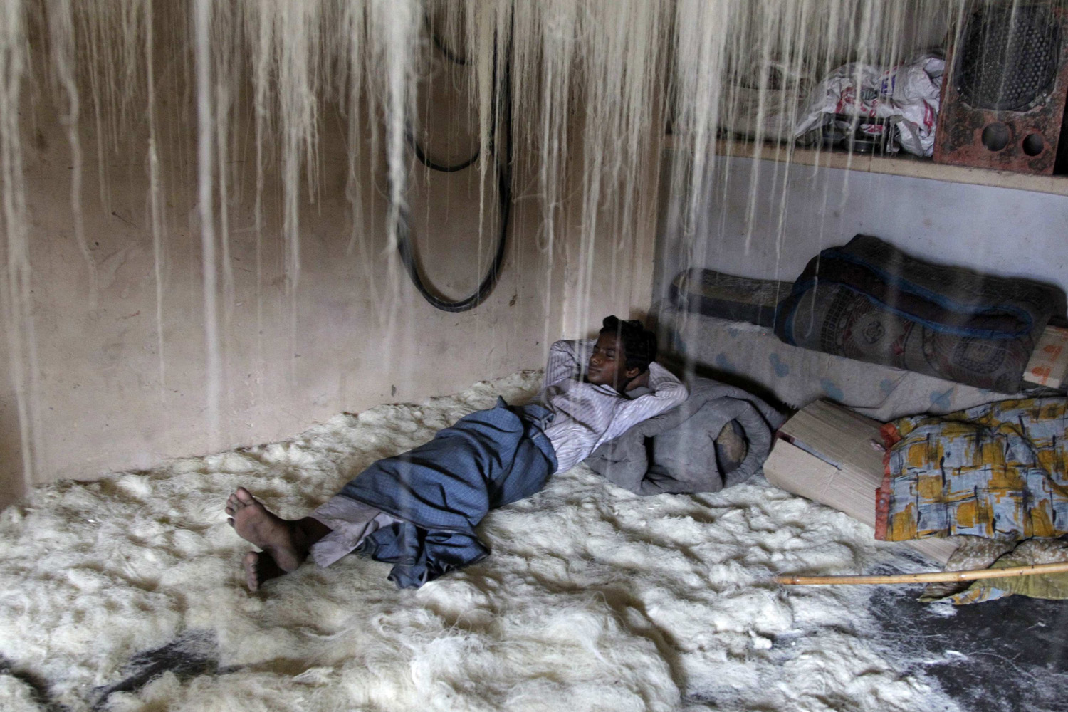 A worker rests on vermicelli inside a factory in Allahabad