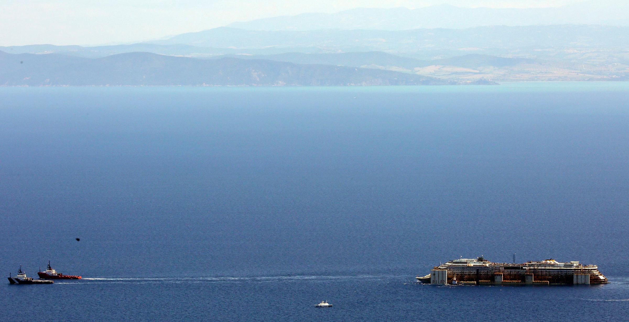 Tugboats drag cruise liner Costa Concordia after leaving Giglio Island