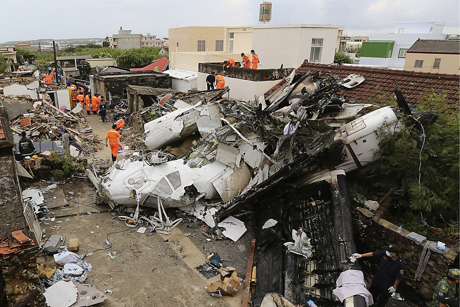 Rescue personnel survey the wreckage of a TransAsia Airways turboprop plane that crashed on Penghu island