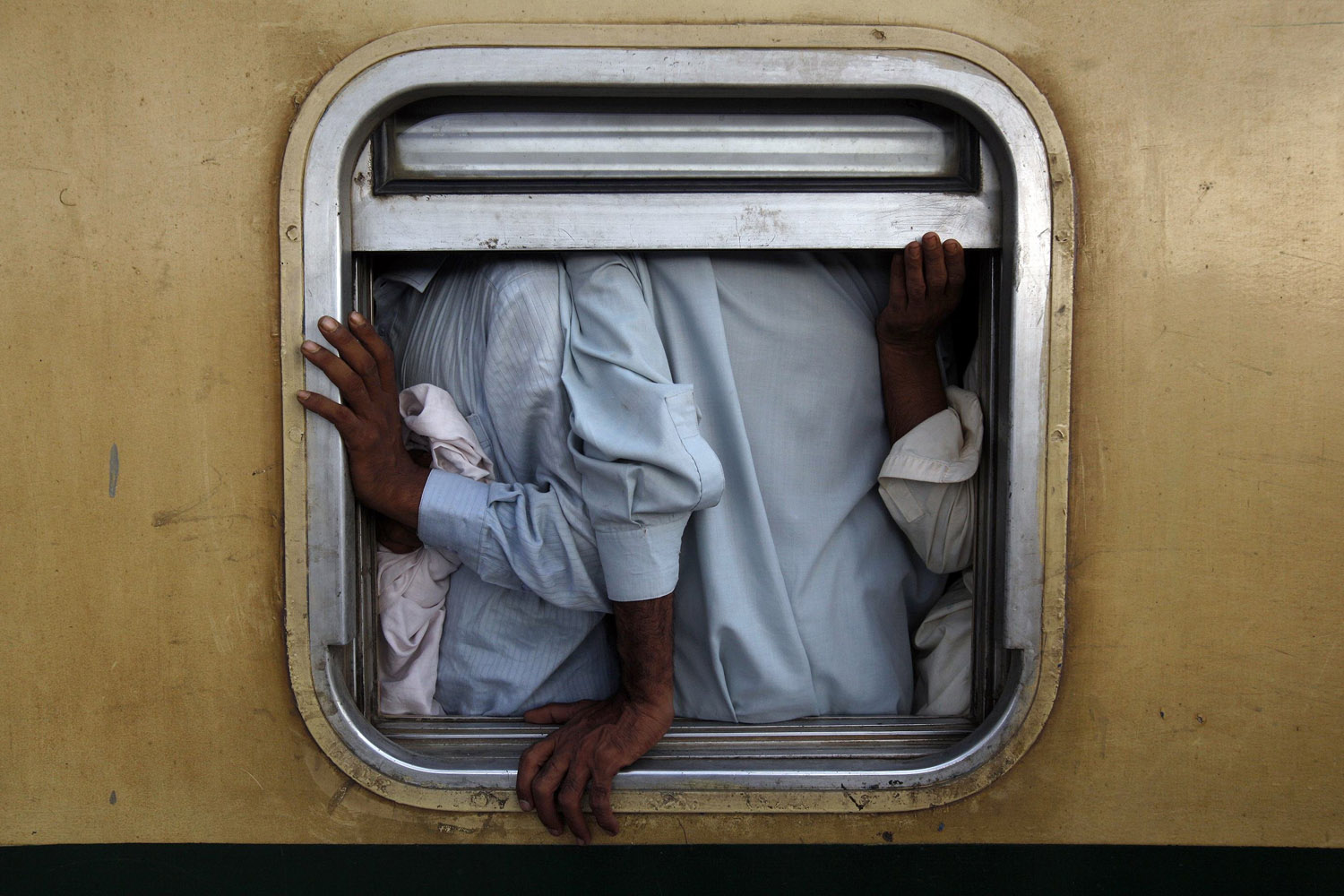 Men are seen at the window of a train as they make their way home, ahead of the Eid al-Fitr festival, at Karachi's Cantonment railway station