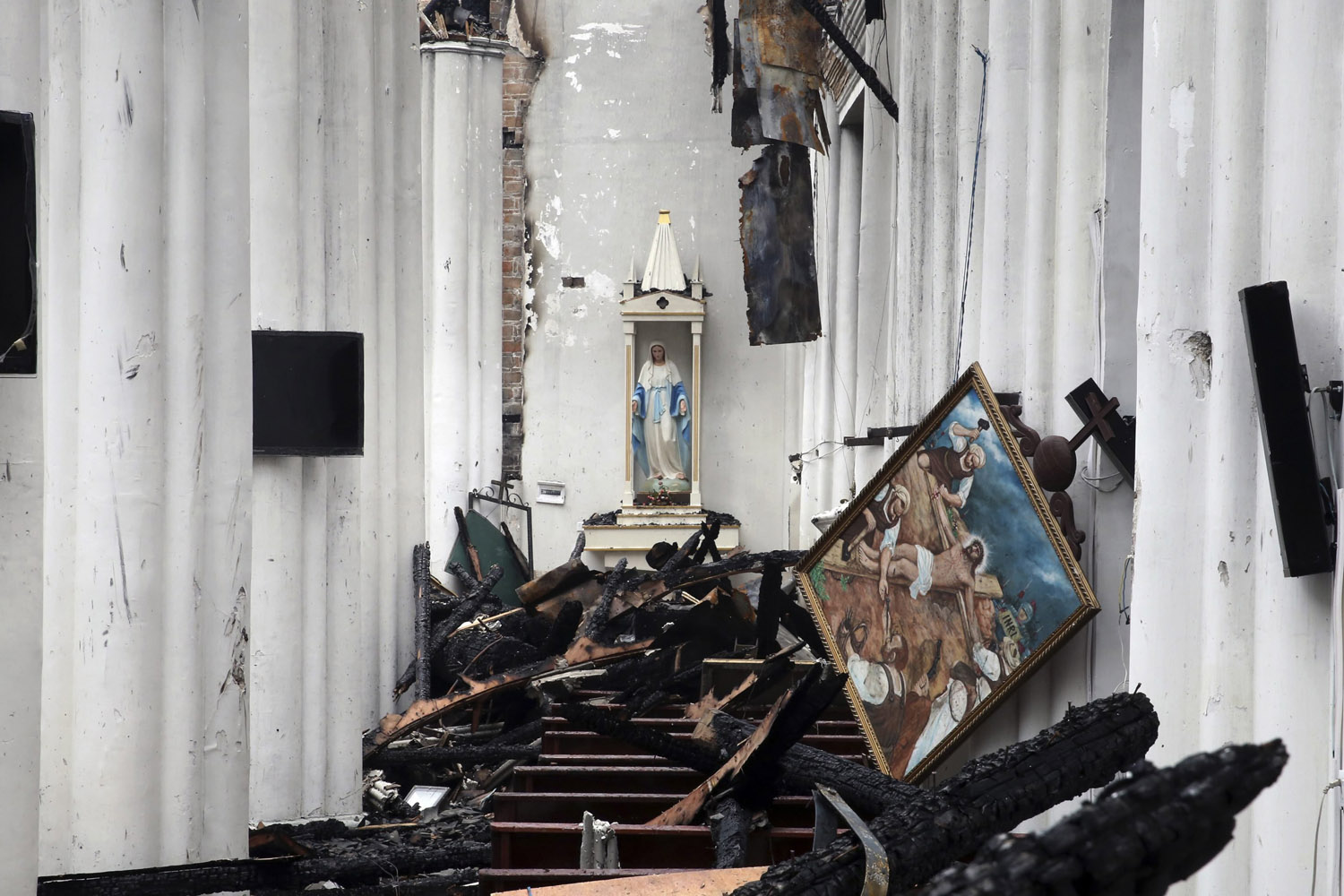 A sculpture and a painting are seen above debris after a fire at the Jiangbei Cathedral in Ningbo