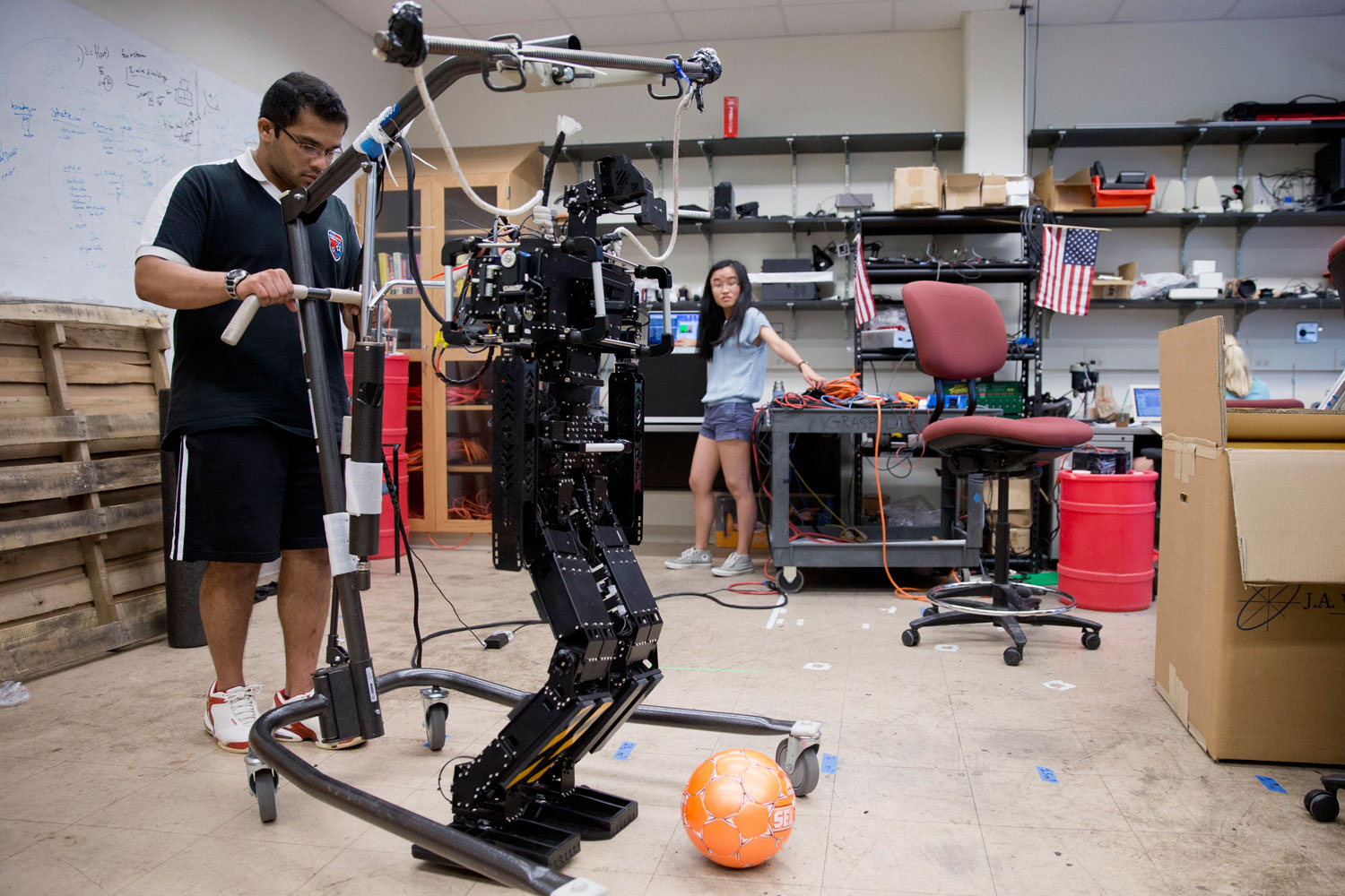 Research associates Larry Vadakedathu, left, and Qin He work with one of their RoboCup entries, a 5-foot-tall metal humanoid named THOR (Tactical Hazardous Operations Robot), in the adult-size league at the University of Pennsylvania in Philadelphia on July 7, 2014.