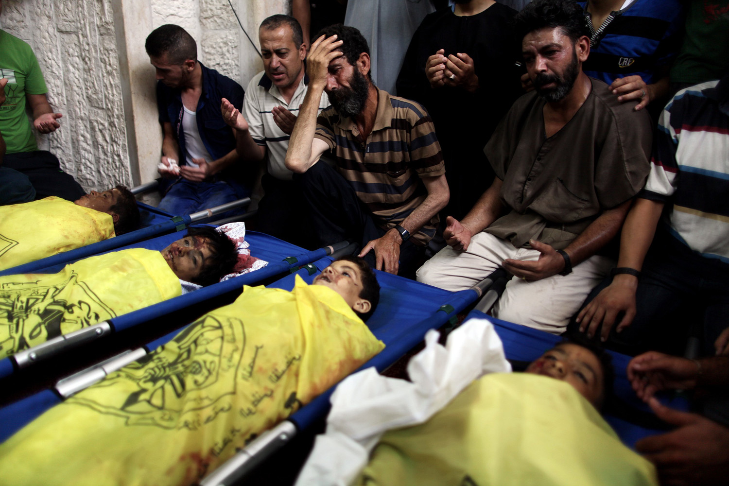 PALESTINIANS MOURN OVER THE BODY OF BOYS FROM THE BAKER FAMILY, WHOM MEDICS SAID WAS KILLED WITH THREE OTHER CHILDREN FROM THE SAME FAMILY BY A SHELL FIRED BY AN ISRAELI NAVAL GUNBOAT