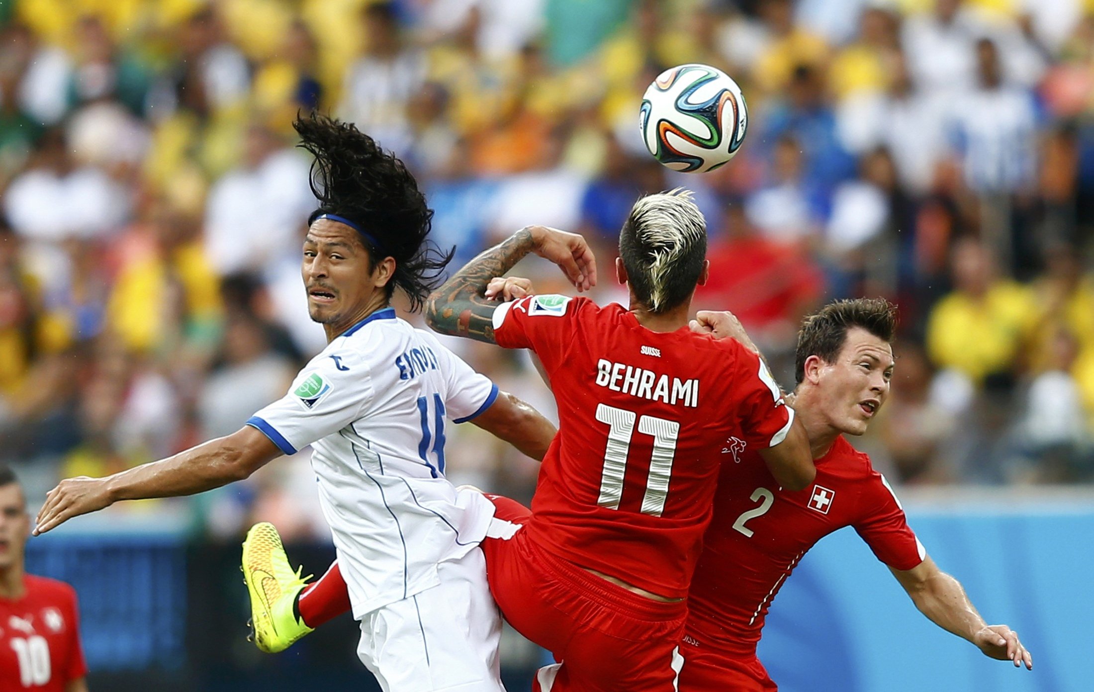 Roger Espinoza of Honduras fights for the ball with Switzerland's Valon Behrami and Stephan Lichtsteiner during their match at the Amazonia arena in Manaus, Brazil onJune 25, 2014.