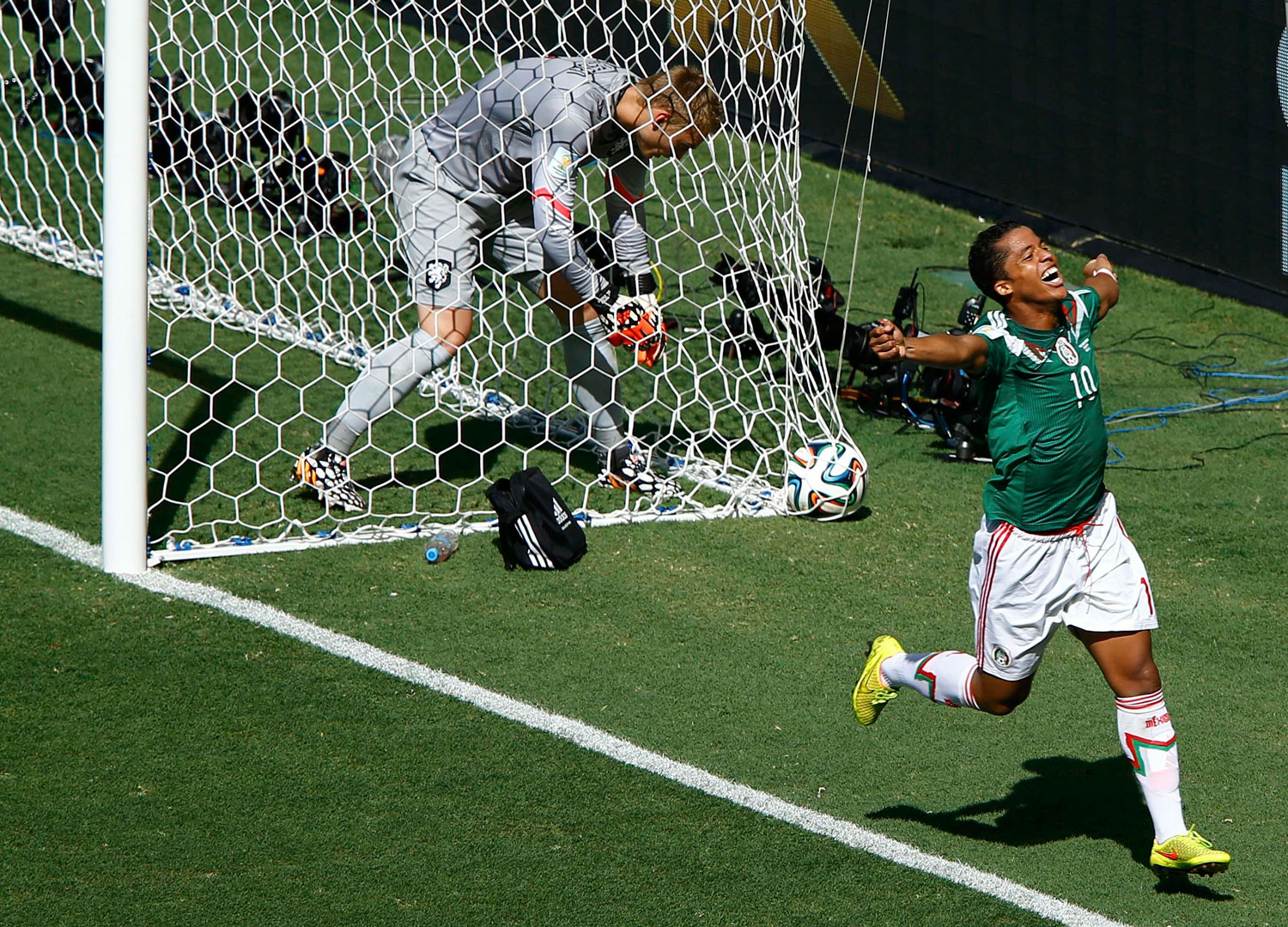 Jasper Cillessen of the Netherlands picks the ball out of the net as Mexico's Giovani Dos Santos celebrates his goal during their game at the Castelao arena in Fortaleza , Brazil on June 29, 2014.