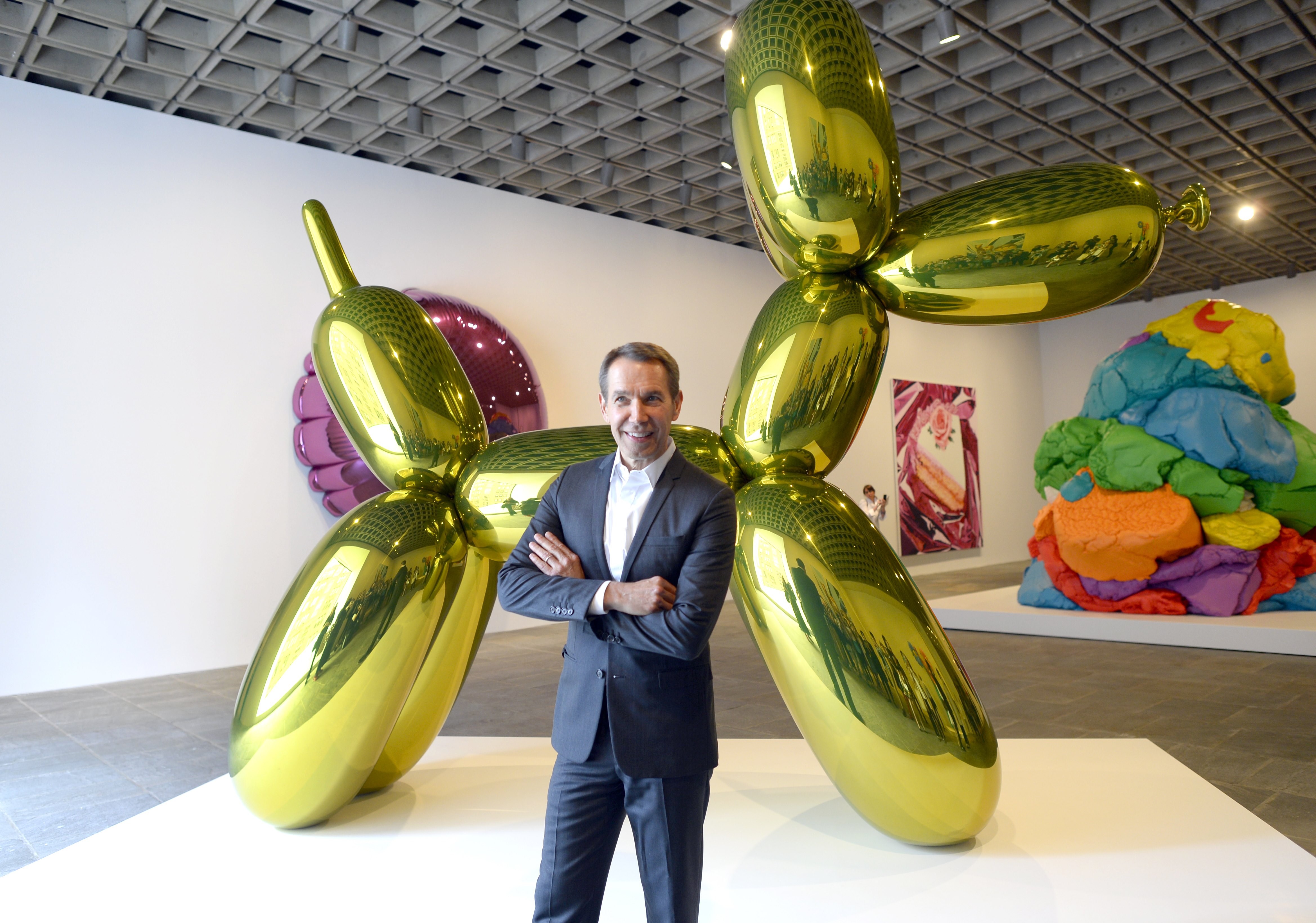 Artist Jeff Koons poses next to one of his sculptures during a press preview of "Jeff Koons: A Retrospective" a exhibition of his work at the Whitney Museum of American Art June 24, 2014. (TIMOTHY A. CLARY&mdash;AFP/Getty Images)