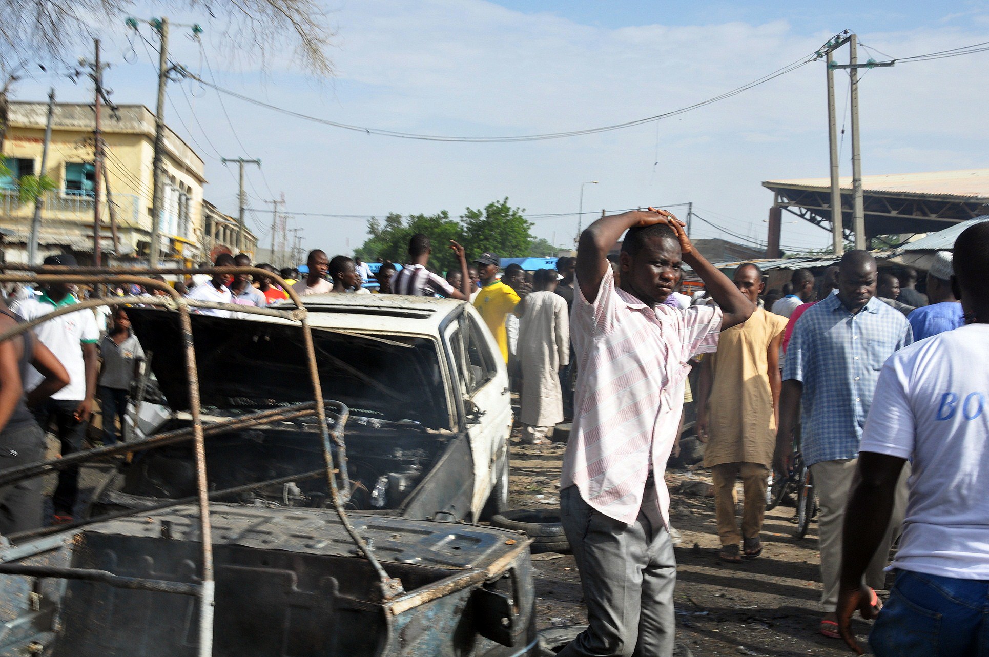 People gather near burned vehicles by the crowded Monday Market in Maiduguri, Nigeria, on July 1, 2014 (AFP—Getty Images)