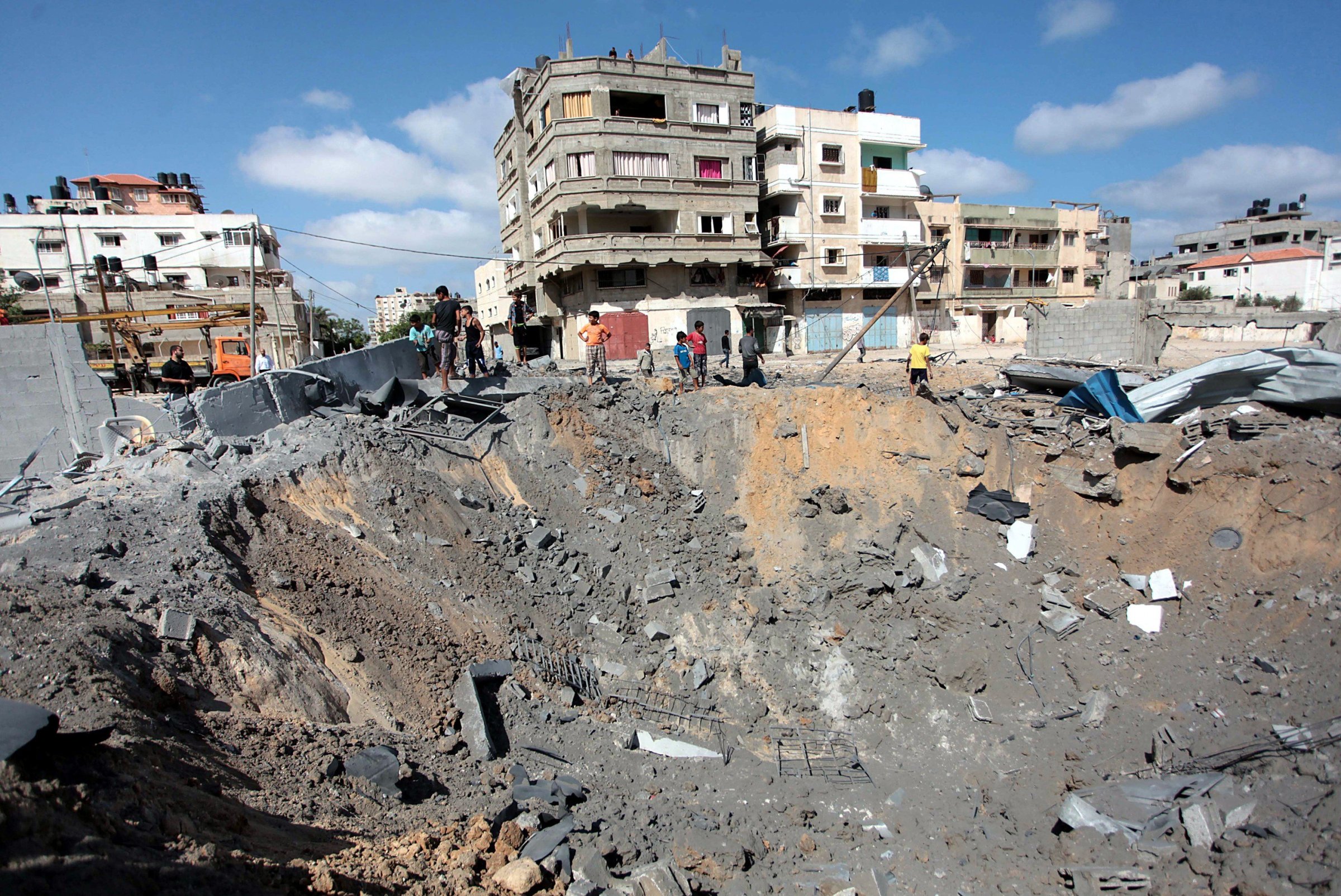 Palestinians inspect damaged areas following an overnight Israeli air strike, on July 3, 2014 in Gaza City, Gaza.