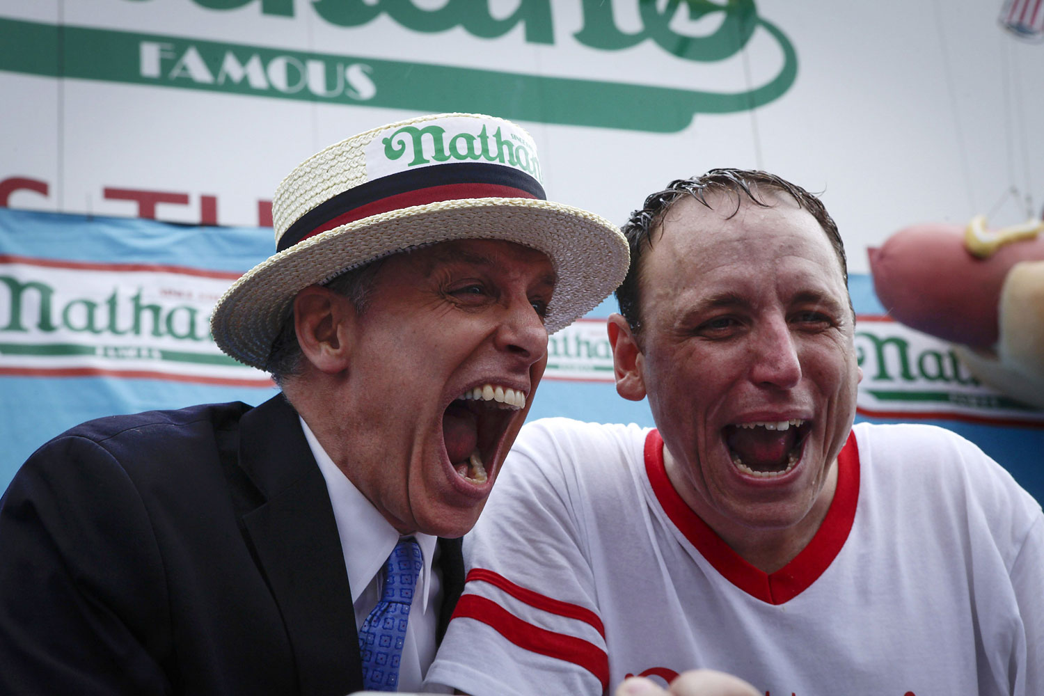 Joey Chestnut, right, and George Shea celebrate after Chestnut wins the 98th annual 2014 Nathan's Famous Hot Dog Eating Contest.