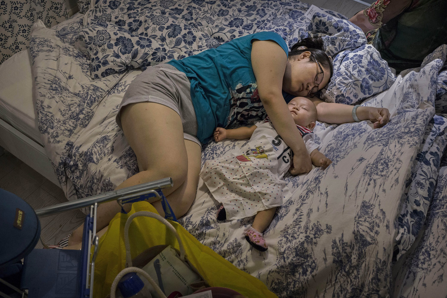Jul. 6, 2014. A Chinese shopper sleeps with her child on a bed in the showroom of the IKEA store on in Beijing, China. Of the world's ten biggest Ikea stores, 8 of them are in China to cater to the country's growing middle class.