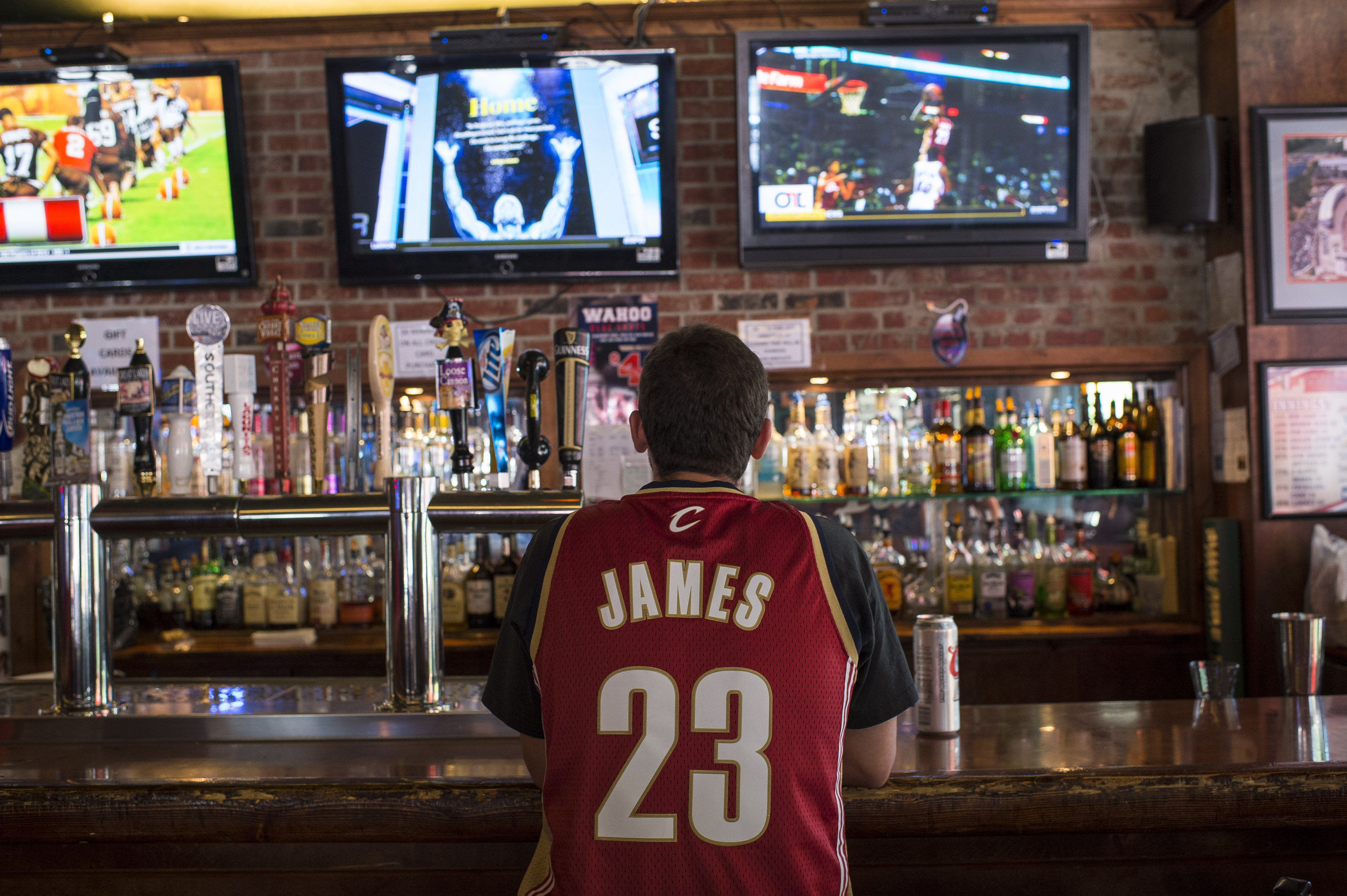 A Cleveland Cavaliers fan watches news coverage of LeBron James' return at Panini's Bar and Grille in downtown Cleveland on July 11, 2014 (Angelo Merendino&mdash;Getty Images)