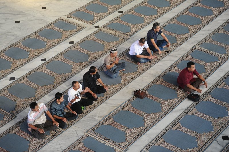 Muslims pray before breaking of the fast during Ramadan on July 13, 2014 in Surabaya, Indonesia.