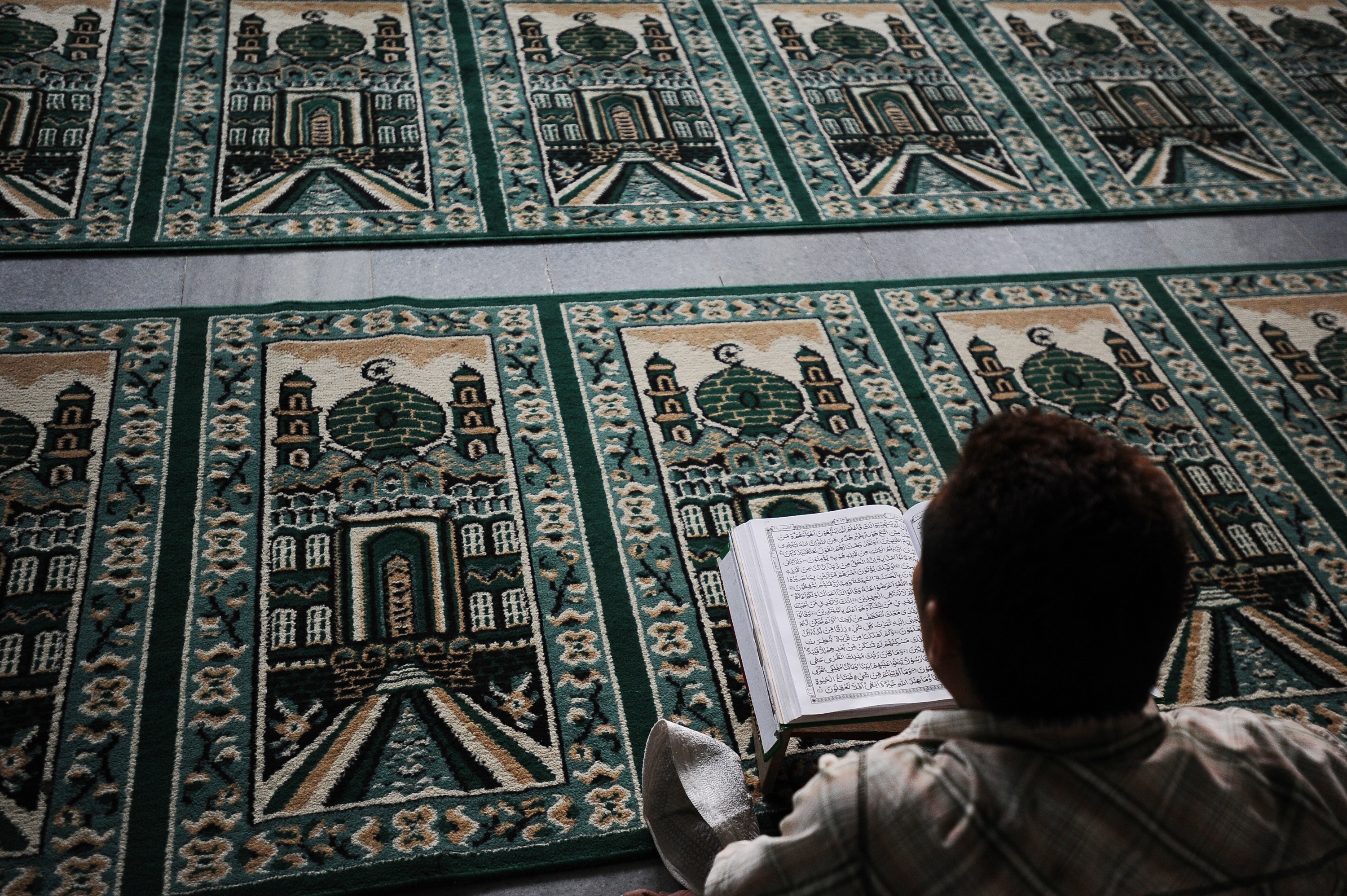 A Muslim man reads the Quran as he waits for the breaking of the fast during Ramadan on July 13, 2014 in Surabaya, Indonesia. (Robertus Pudyanto&mdash;Getty Images)