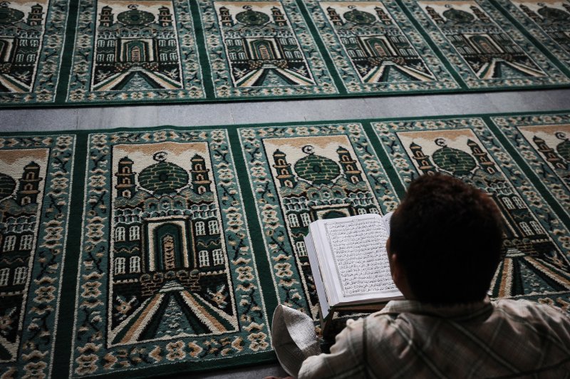 A Muslim man reads the Quran as he waits for the breaking of the fast during Ramadan on July 13, 2014 in Surabaya, Indonesia.