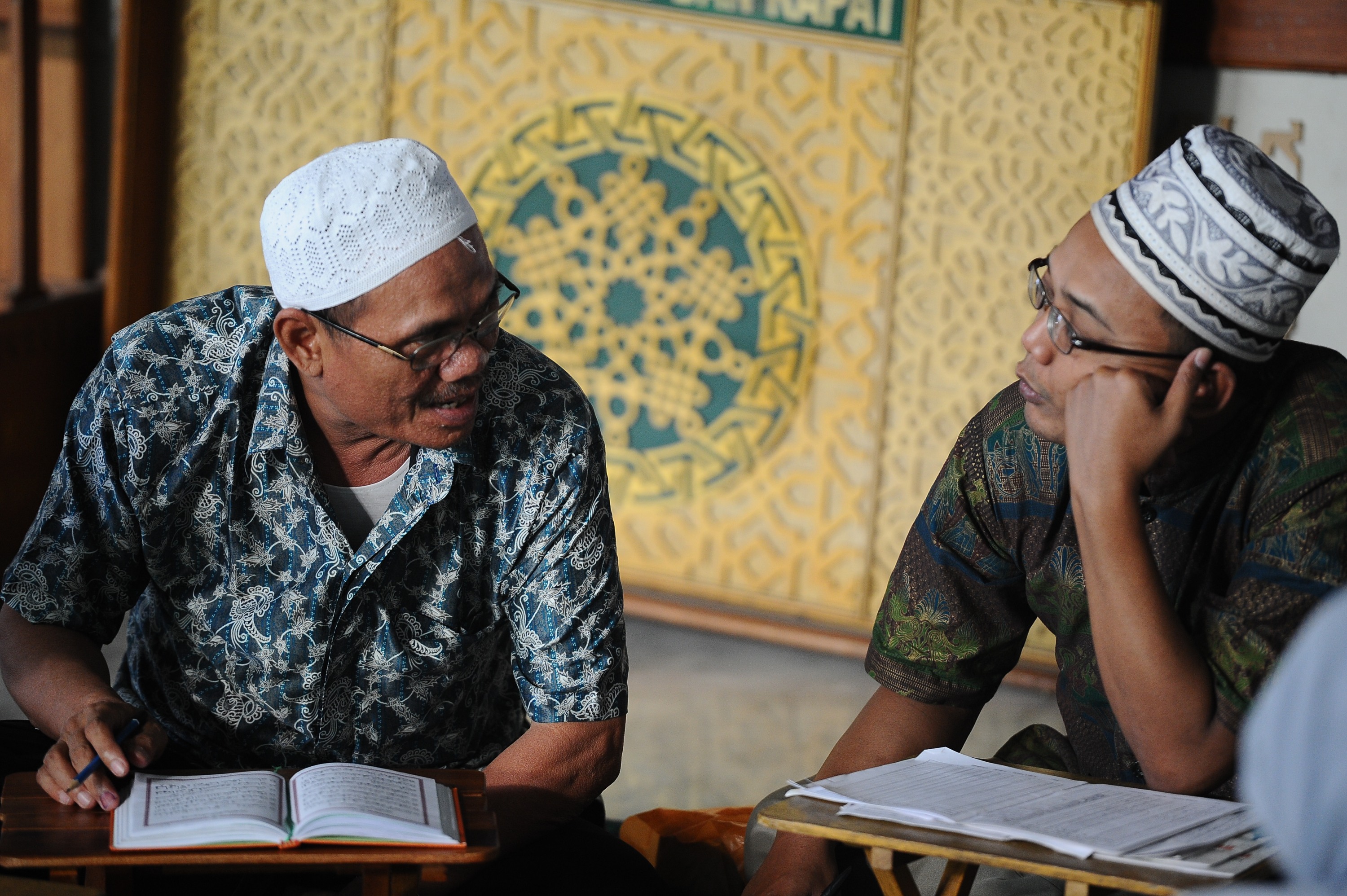 Muslim men read the Quran as they wait for the breaking of the fast during Ramadan on July 13, 2014 in Surabaya, Indonesia. (Robertus Pudyanto&mdash;Getty Images)