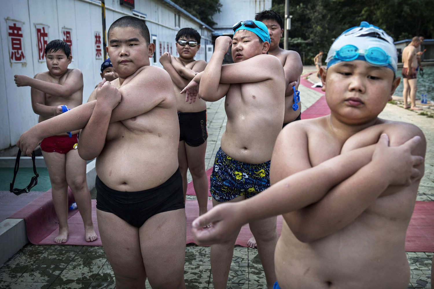 Overweight Chinese students stretch after swimming during training at a camp held for overweight children in Beijing on July 15, 2014.