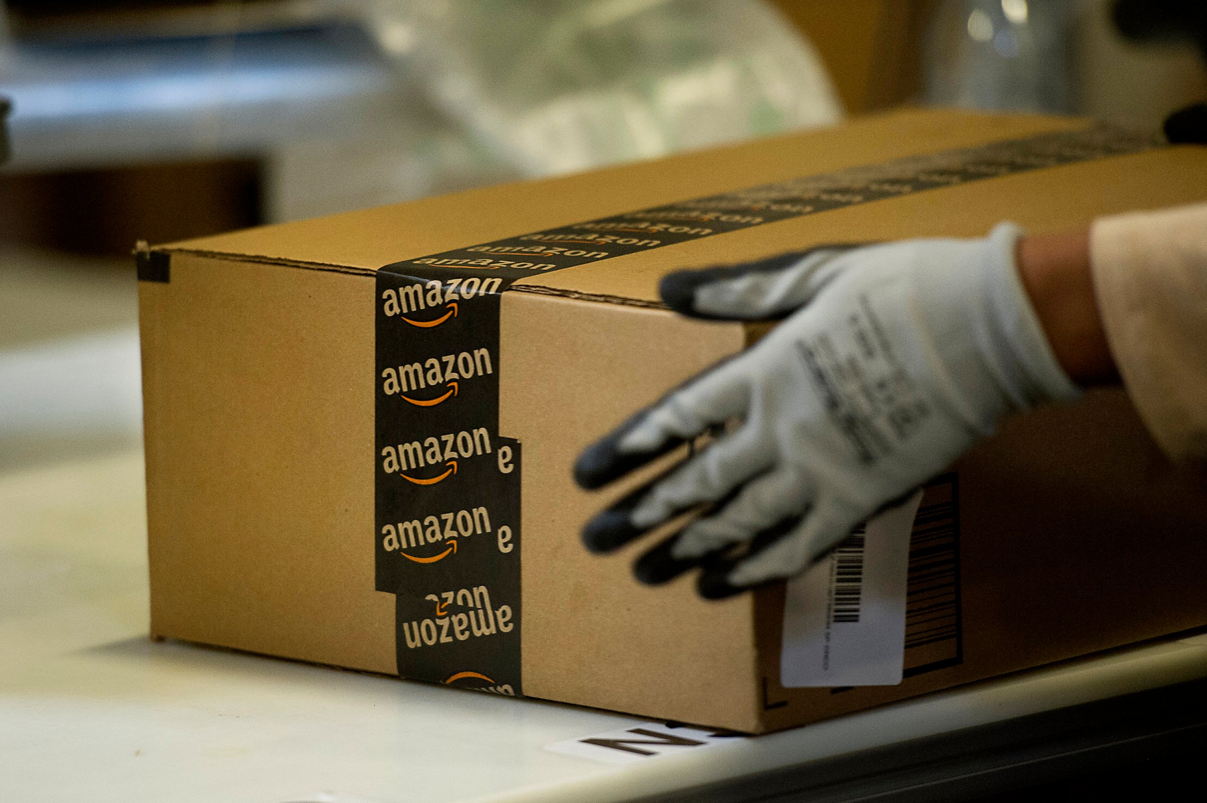 An employee seals a box at the Amazon.com Inc. fulfillment center in Phoenix, Arizona on Dec. 2, 2013.