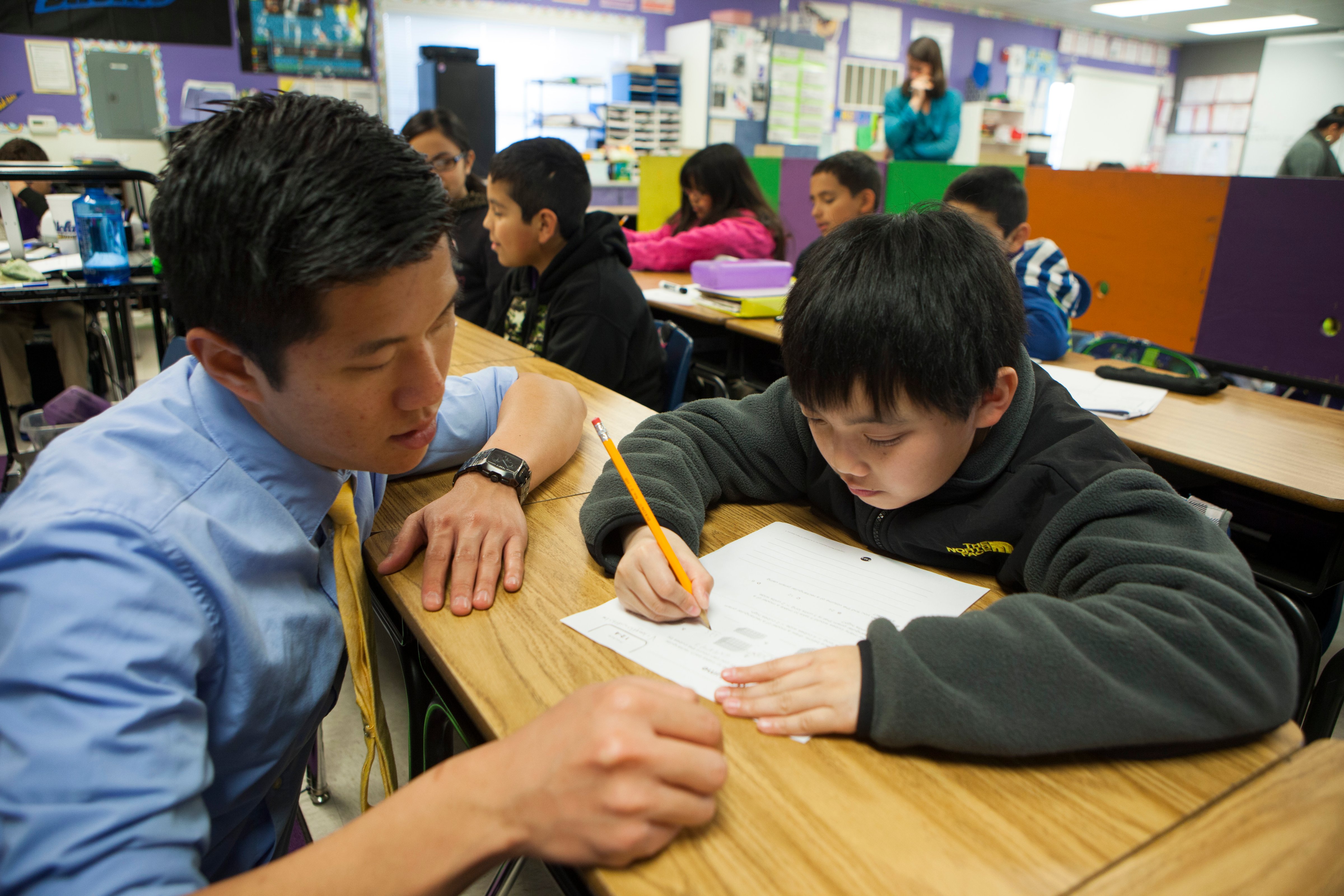 Fifth grade science and math teacher Stephen Pham helps a student at Rocketship SI Se Puede, a charter, public elementary school, on Feb. 18, 2014 in San Jose, California. (Melanie Stetson Freeman—The Christian Science Monitor/Getty Images)