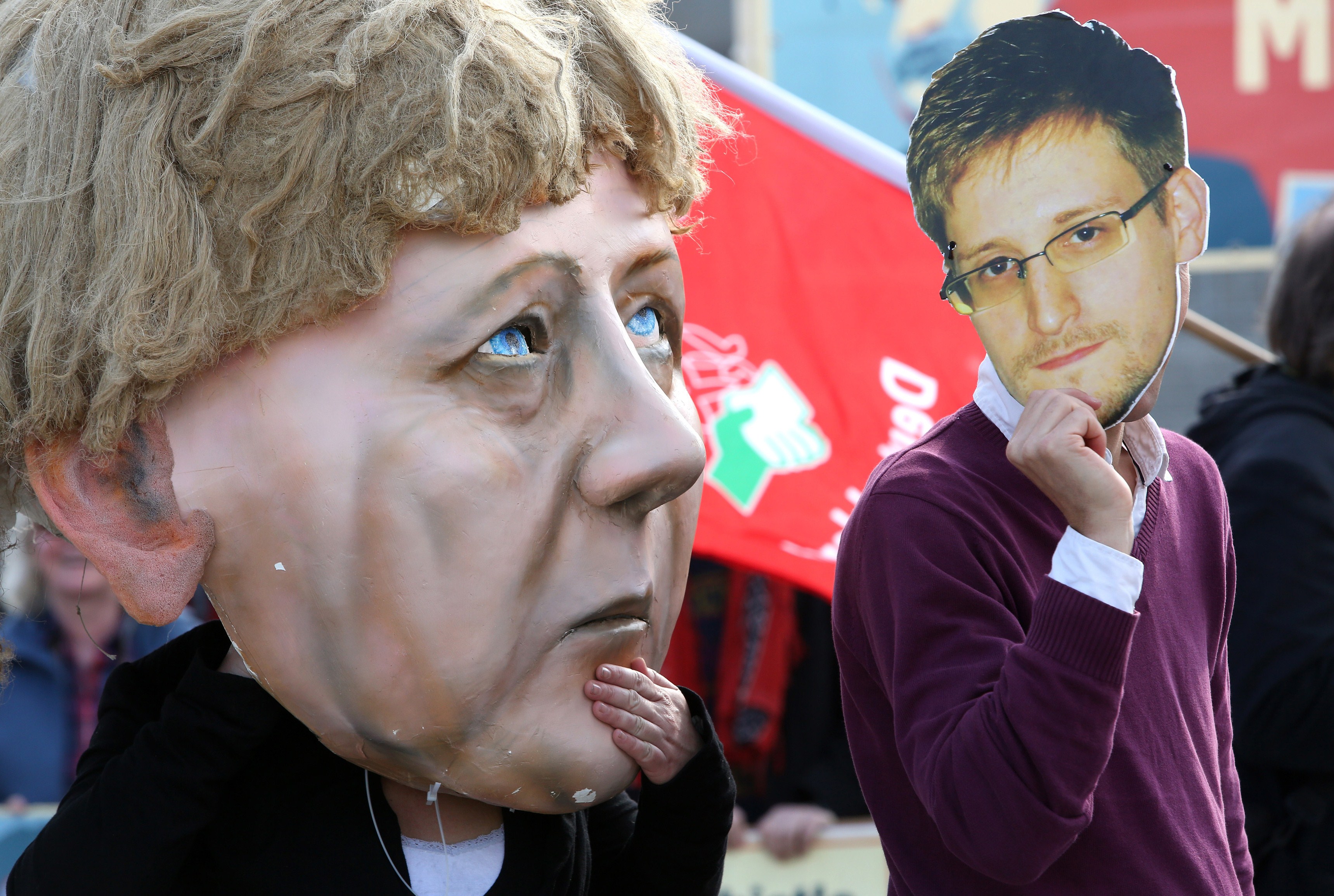 Activists wearing a mask of fugitive U.S. intelligence leaker Edward Snowden (R) and of German Chancellor Angela Merkel take part in a demonstration in favor of an appearance by Snowden as a witness in German NSA hearings held in the German Bundestag, or lower house of parliament, outside the Reichstag building in Berlin on May 8, 2014. (ADAM BERRY&mdash;AFP/Getty Images)