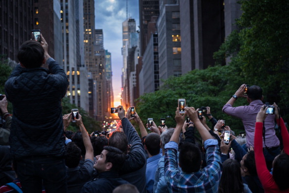 Photographers gather on the Tudor City Place overpass to capture the Manhattenhenge looking across 42nd Street in the Manhattan borough of New York, New York, USA. (Zoran Milich—Getty Images)