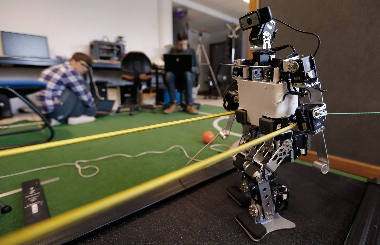 Members of the Rhoban project's team check functions of a humanoid robot at the LaBRI workshop in Talence, France on July 7, 2014.