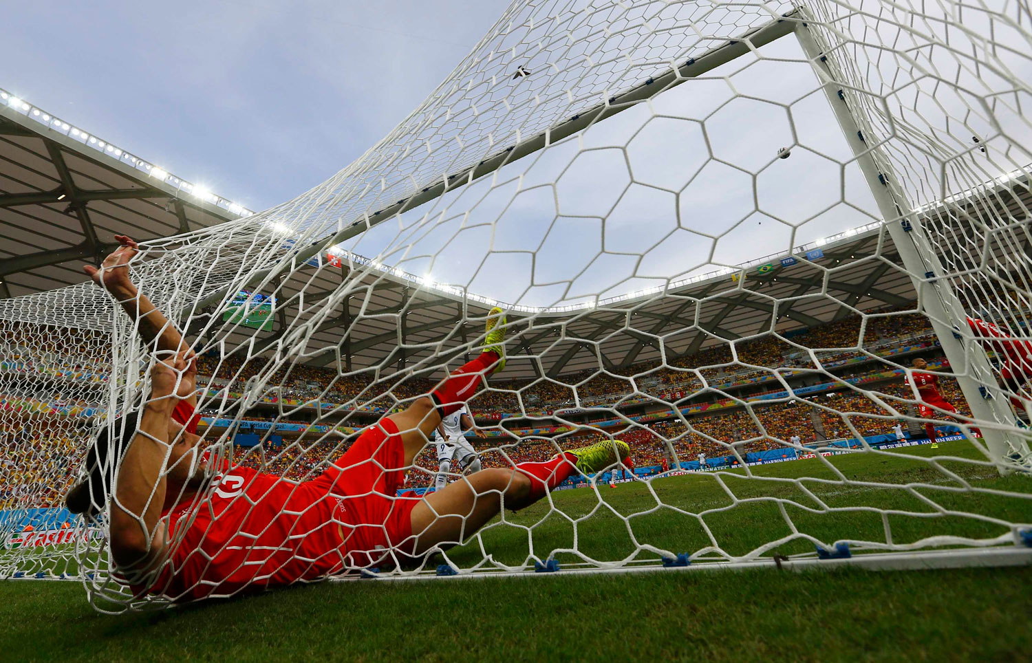 Switzerland's Ricardo Rodriguez falls into the goal net after making a save during their match against Honduras at the Amazonia arena in Manaus, Brazil on June 25, 2014.