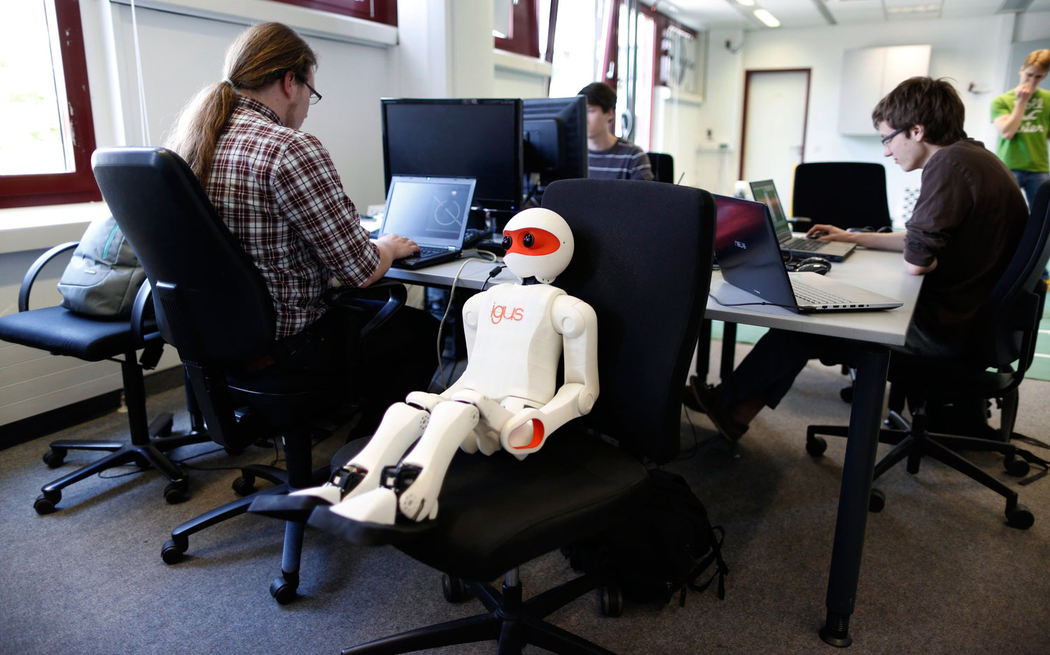 People work on the software of humanoid robots during a photo opportunity at the Institute for Computer Science at the University of Bonn in Bonn, Germany on July 3, 2014.