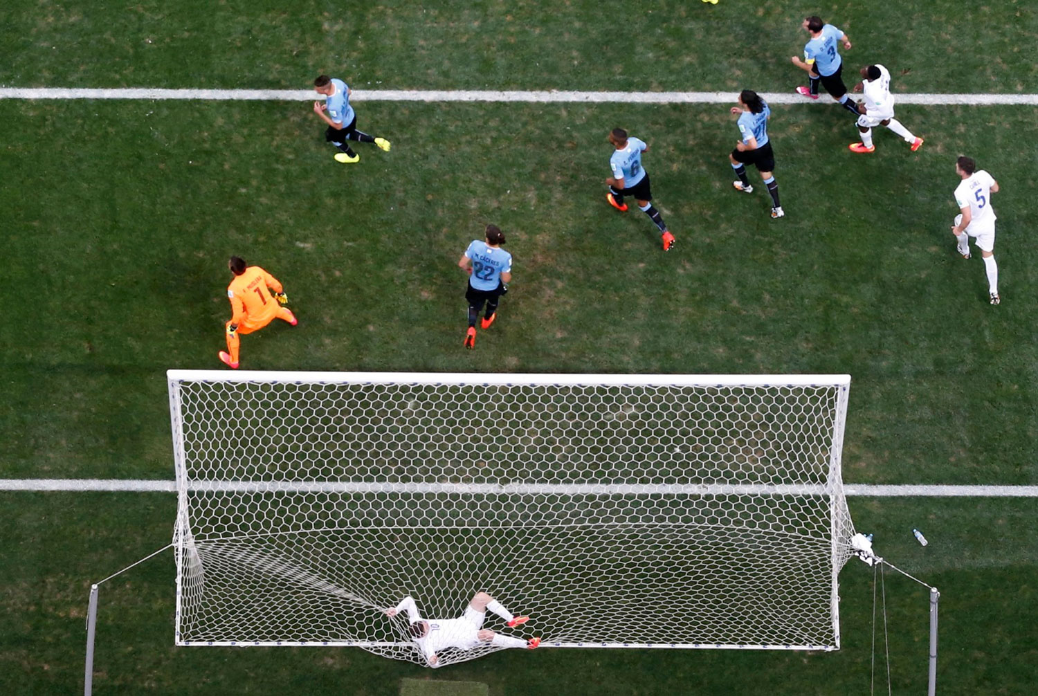 England's Wayne Rooney tangles himself in the net after failing to score a goal against Uruguay during their match at the Corinthians arena in Sao Paulo on June 19, 2014.