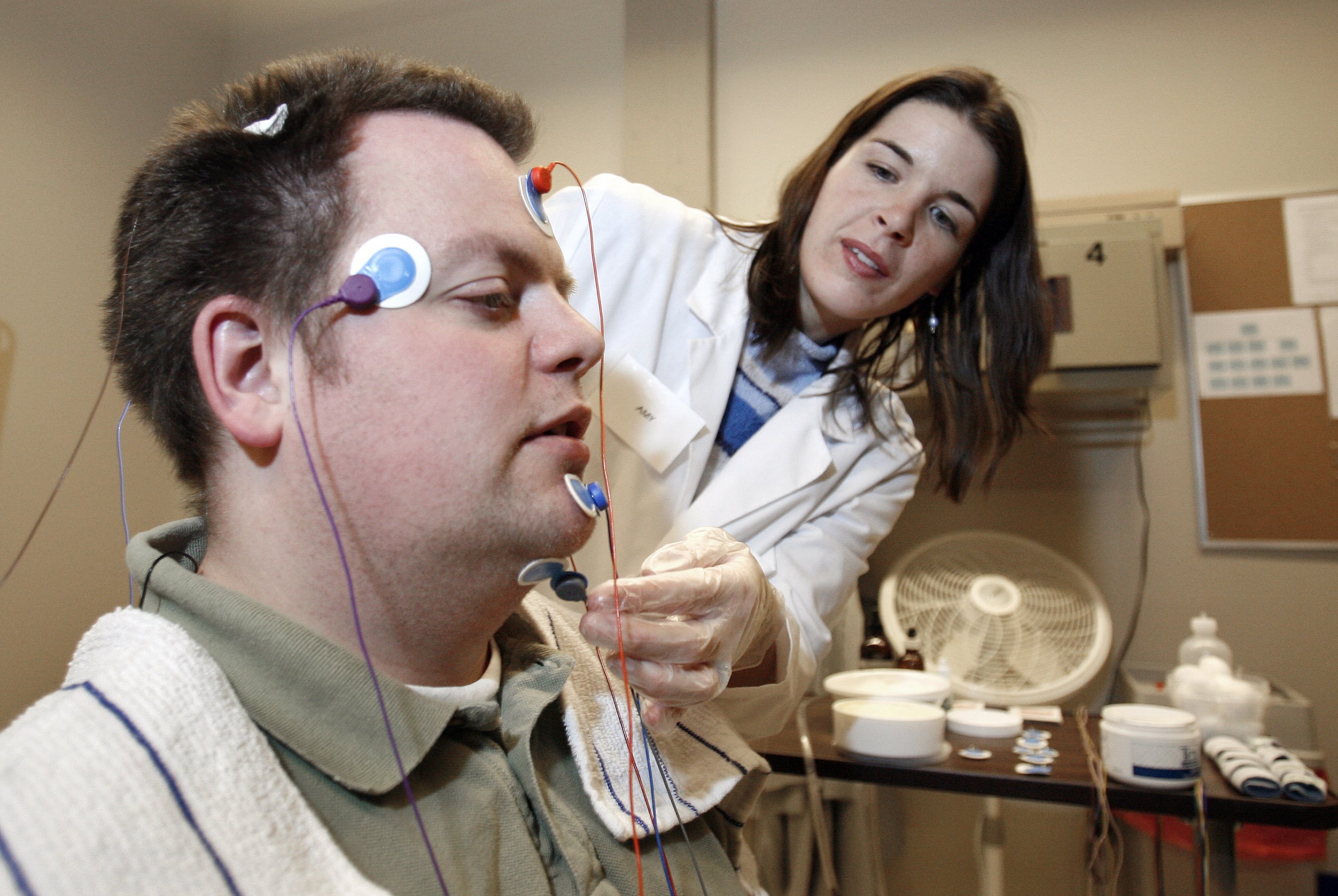 Ryan Gamble has wires applied to his head by lab technologist Amy Bender in preparation for a polysomnographic recording system demonstration at Washington State University Spokane's Sleep and Performance Research Center December 13, 2006 in Spokane, Washington. (Jeff T. Green—Getty Images)