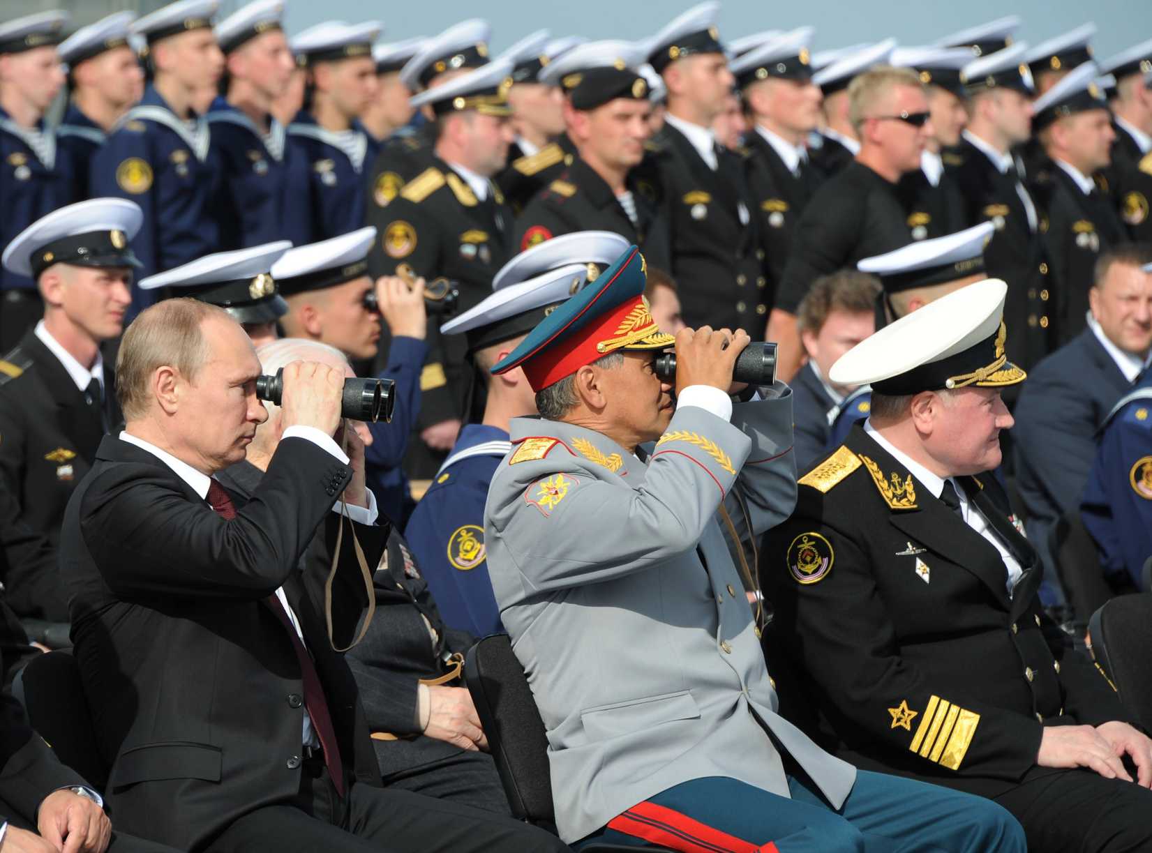 Russian President Vladimir Putin, left, and Russian Defense Minister Sergei Shoigu, center, use binoculars to watch a parade marking the country's Navy Day in Severomorsk, Russia, In this Sunday, on July 27, 2014 (Mikhail Klimentyev—RIA Novosti Kremlin/AP)