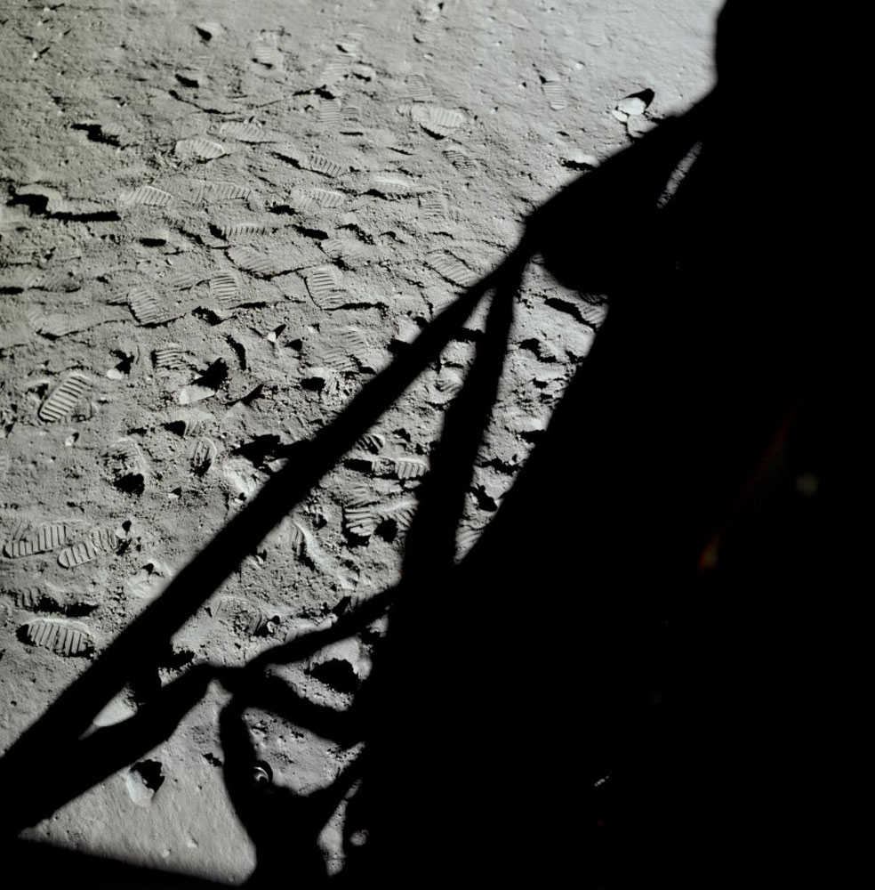 The black shadow of the LM is silhouetted against the Moon's surface in this photograph taken out Neil's window after they had returned to the LM.