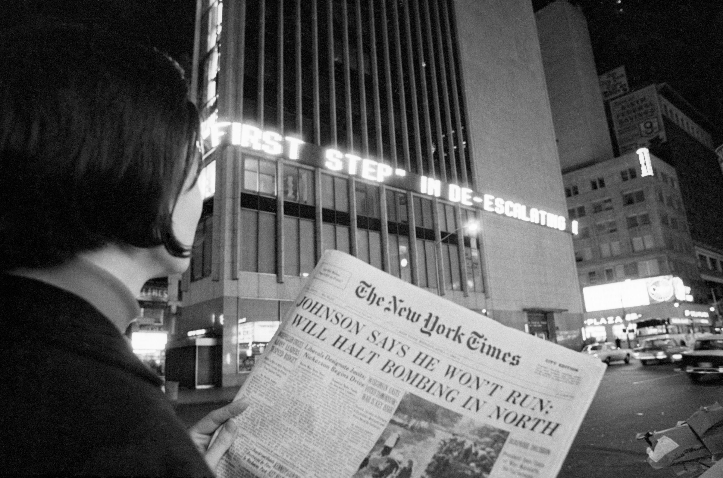 A woman reads the first page of the New York Times of Aril 1, 1968, when the headlines declared : "Johnson Says He Won't Run; Will Halt Bombing in North". This referred to President Johnson's refusal to accept or seek renomination.