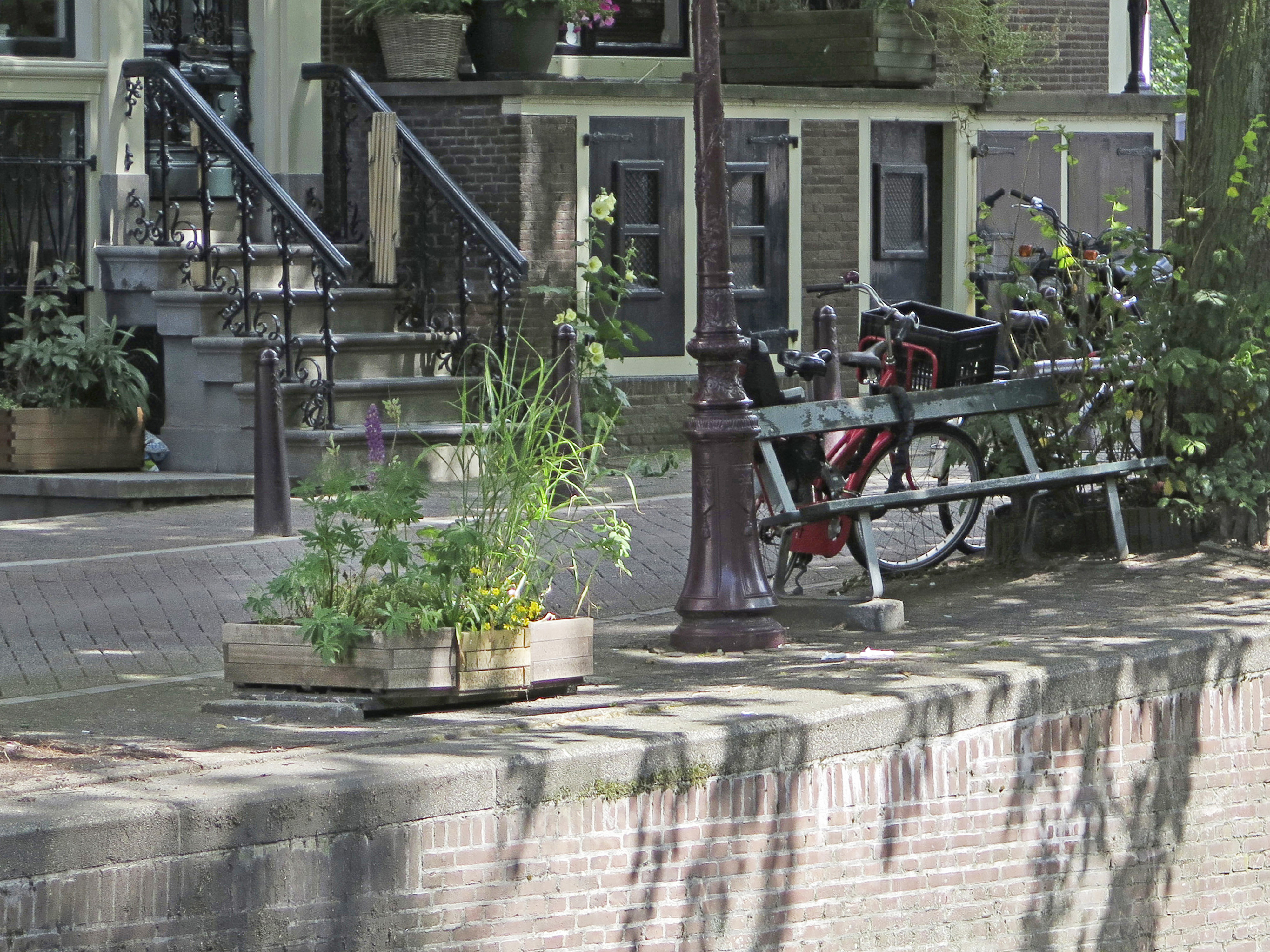 A large plant pot, at left, sits in the spot where a bench similar to the one at right, once sat, in Amsterdam on  July 1, 2014. (Margriet Faber—AP)
