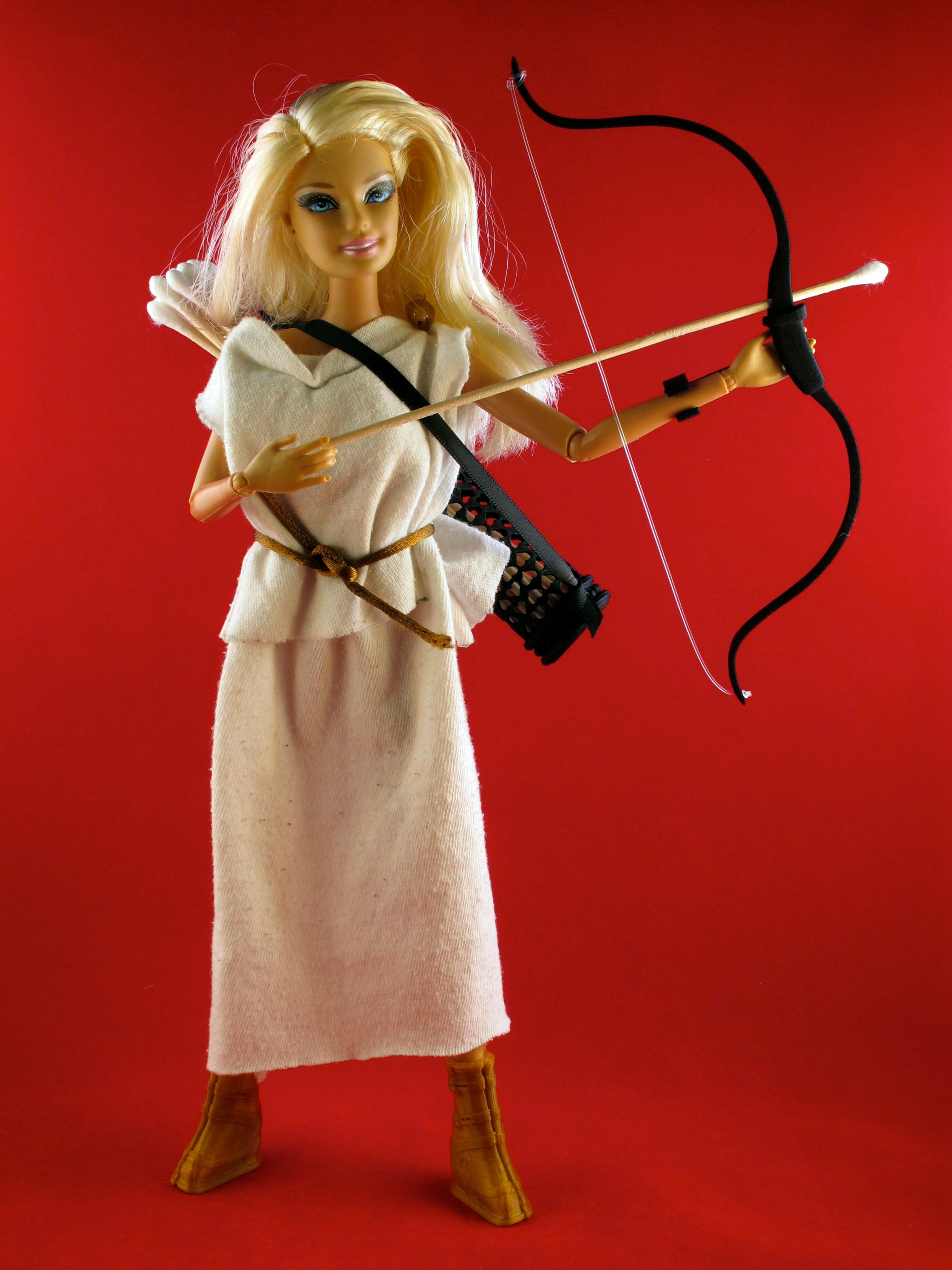 Barbie holds a bow and arrow in her medieval robe.