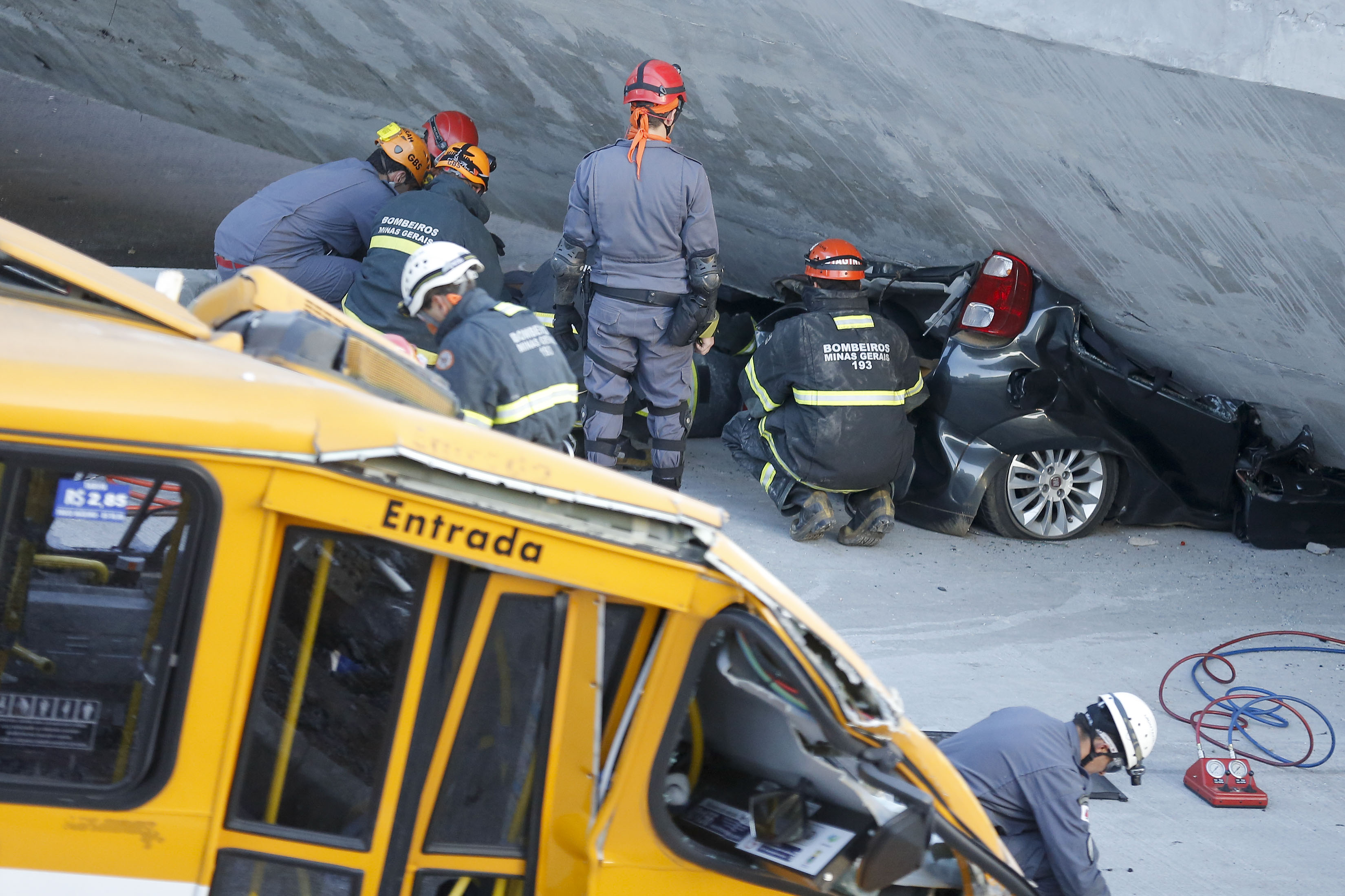 Fire department personnel work to retrieve a car from underneath a collapsed bridge in Belo Horizonte, Brazil, Thursday, July 3, 2014. (Victor R. Caivano—AP)